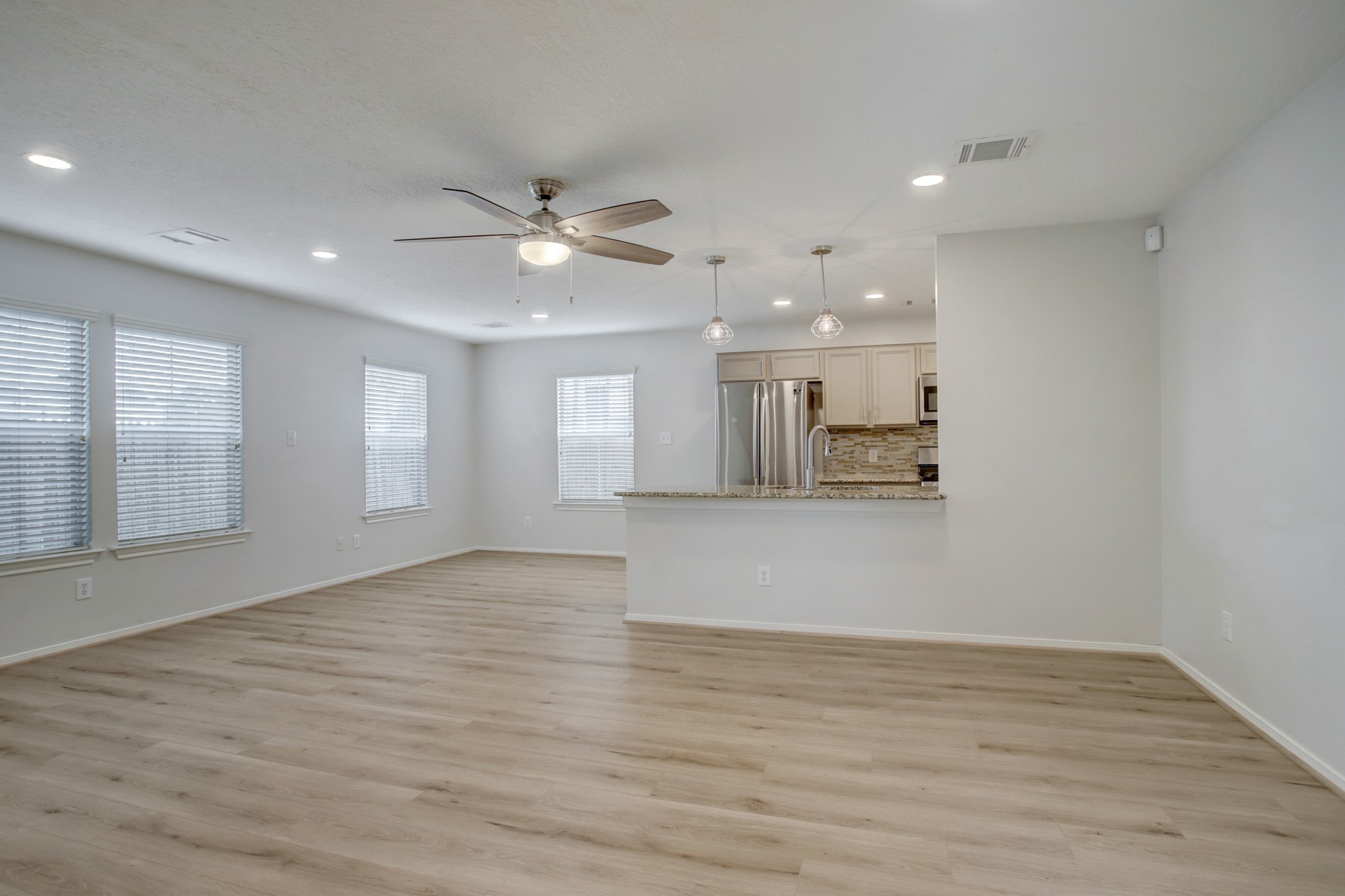 Spacious living area, open floor plan with new flooring and contemporary lighting.