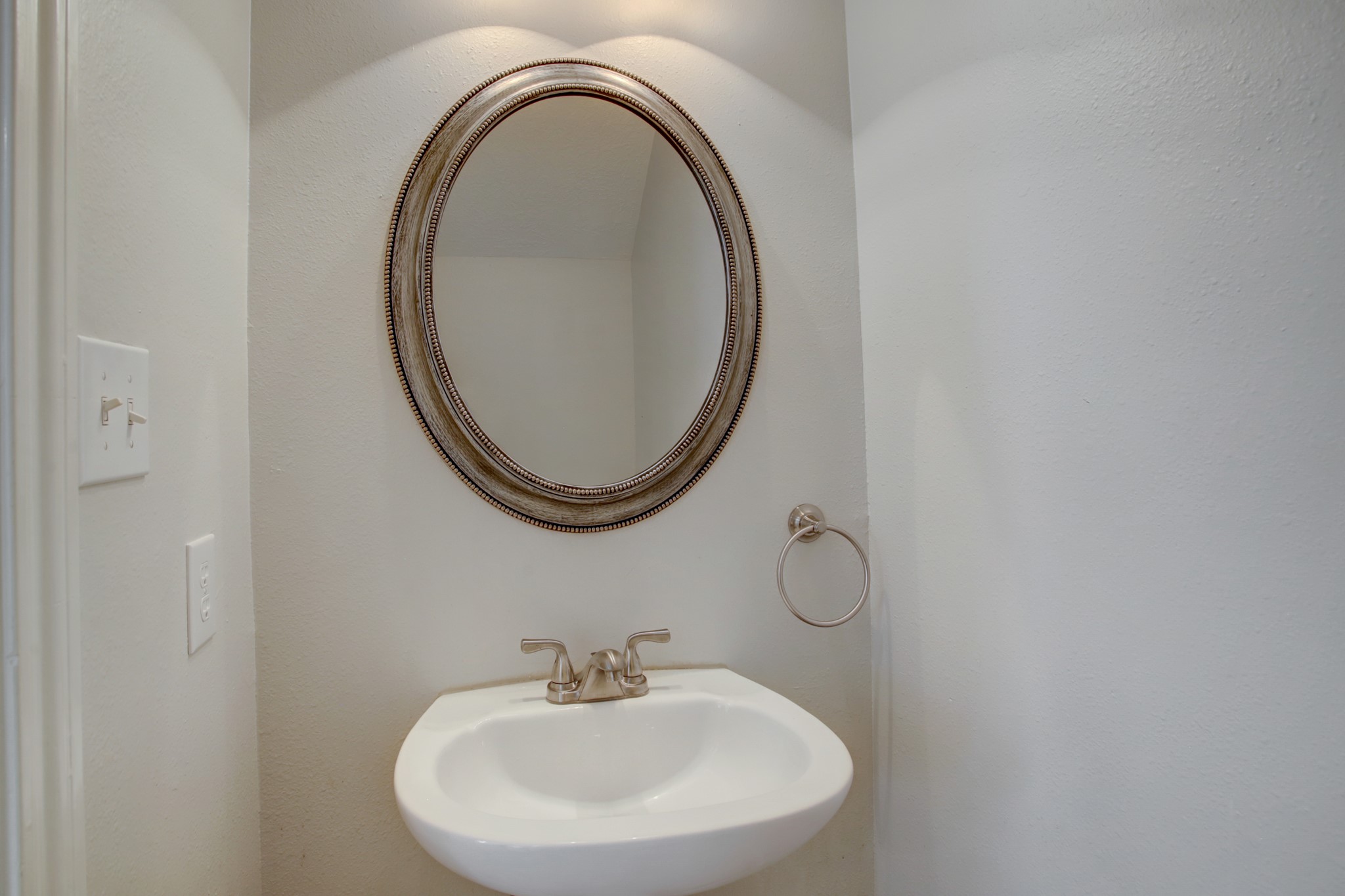 Nicely updated half bath with pedestal sink and framed mirror conveniently located.
