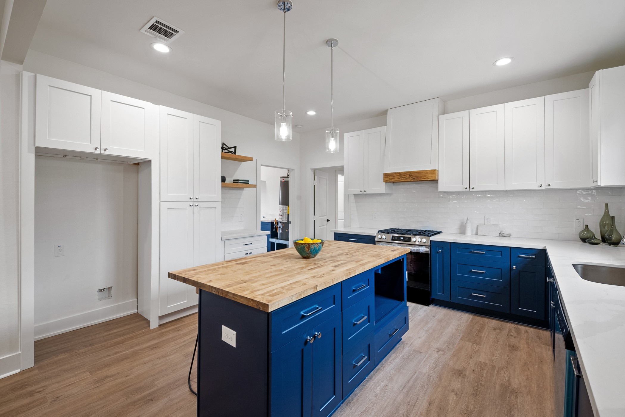 Embracing the soothing vibes of a blue island oasis and surrounded by the warmth of wood grain island top, this kitchen is a blend of modern convenience and rustic charm. Island has a built-in microwave perfectly nestled in its own space. Cooking never felt so stylish and inviting!