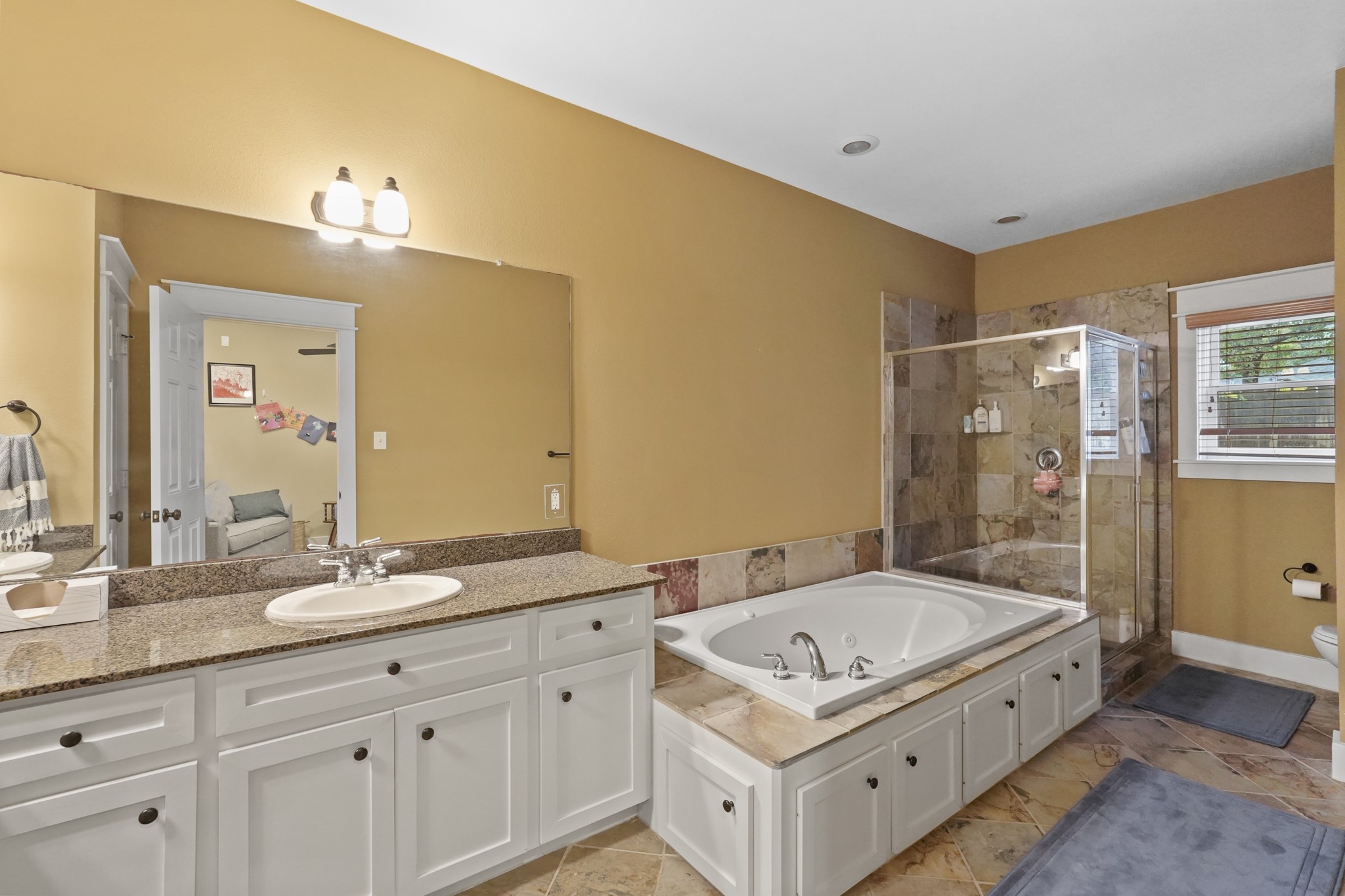 The primary bath features dual vanities & a separate tub & shower.