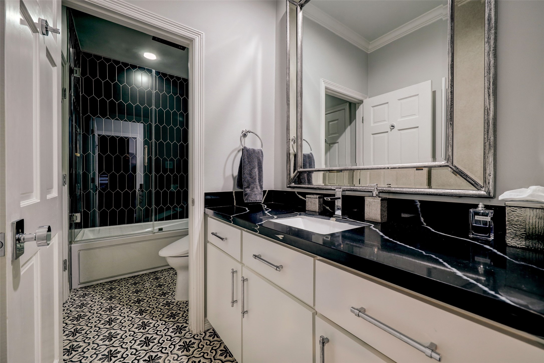 ...a chicly updated private Bath with ebony quartz counters, and tile surround, plus a brilliantly pattered complimentary tile on the floor.