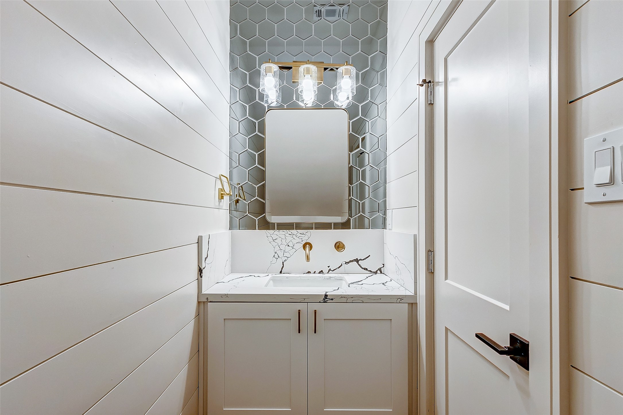Downstairs you have a half-bathroom, perfect for first floor functionality. Visiting family and friends will appreciate the Quartz counters, mirrored backsplash, gold hardware, stylish framed mirror and luxe vanity lighting!