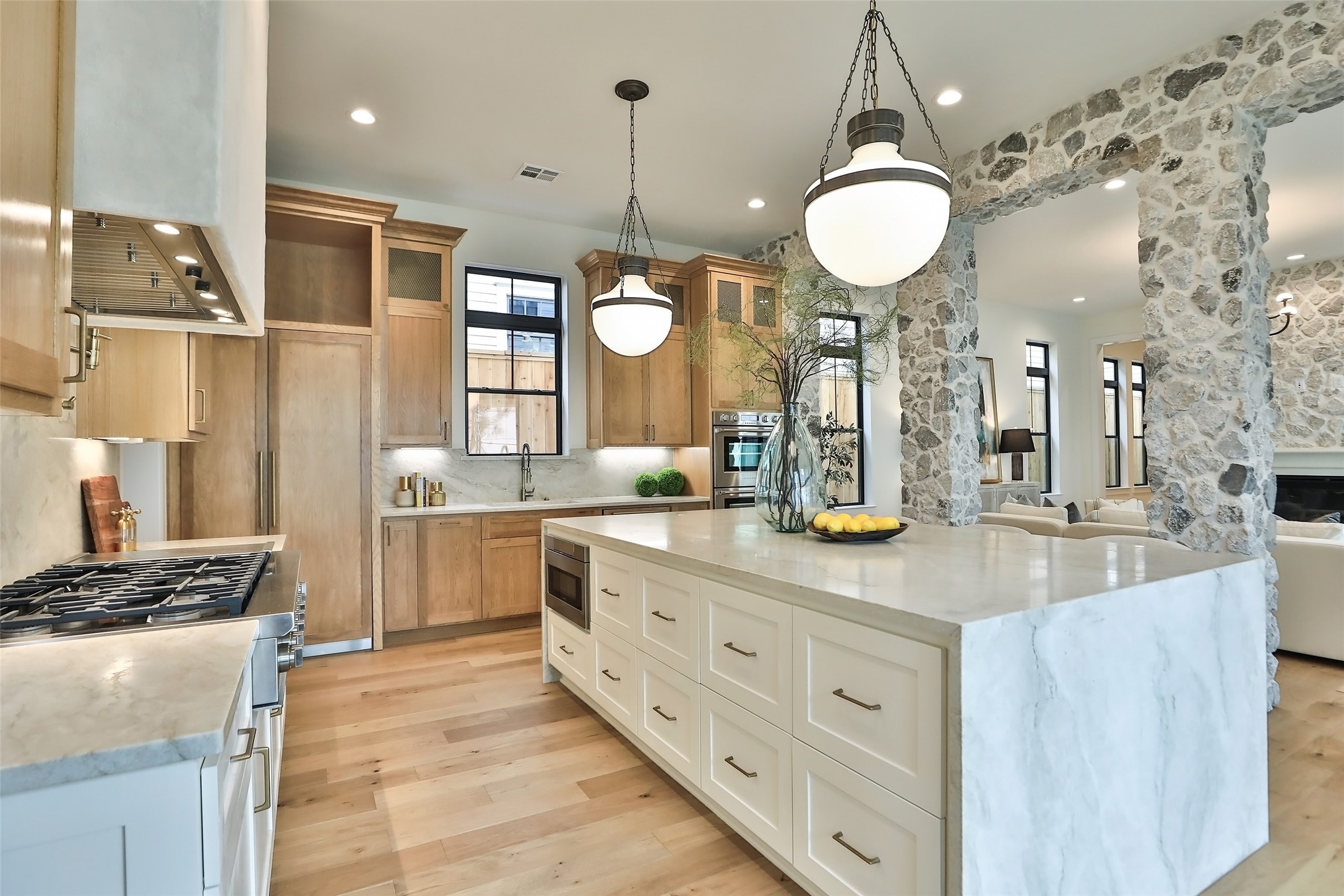 The oversized designer pendants light up the kitchen beautifully. The gas range includes 6-burners plus a griddle. A convenient pot filler is in the custom back splash.