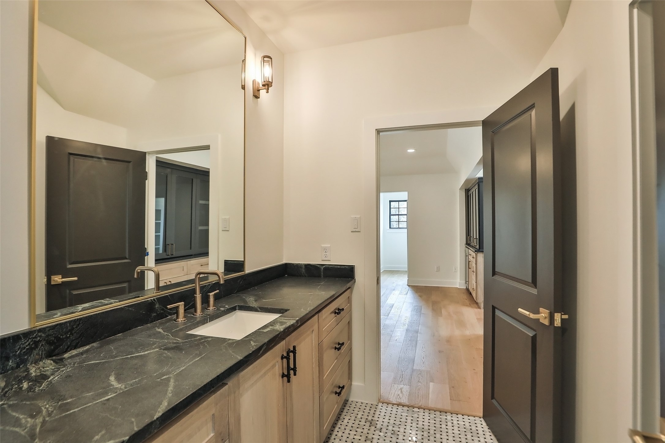 This bathroom opens up a connects the front gathering space and front bedroom. The counters are Soapstone and the flooring is marble basket weave tile.