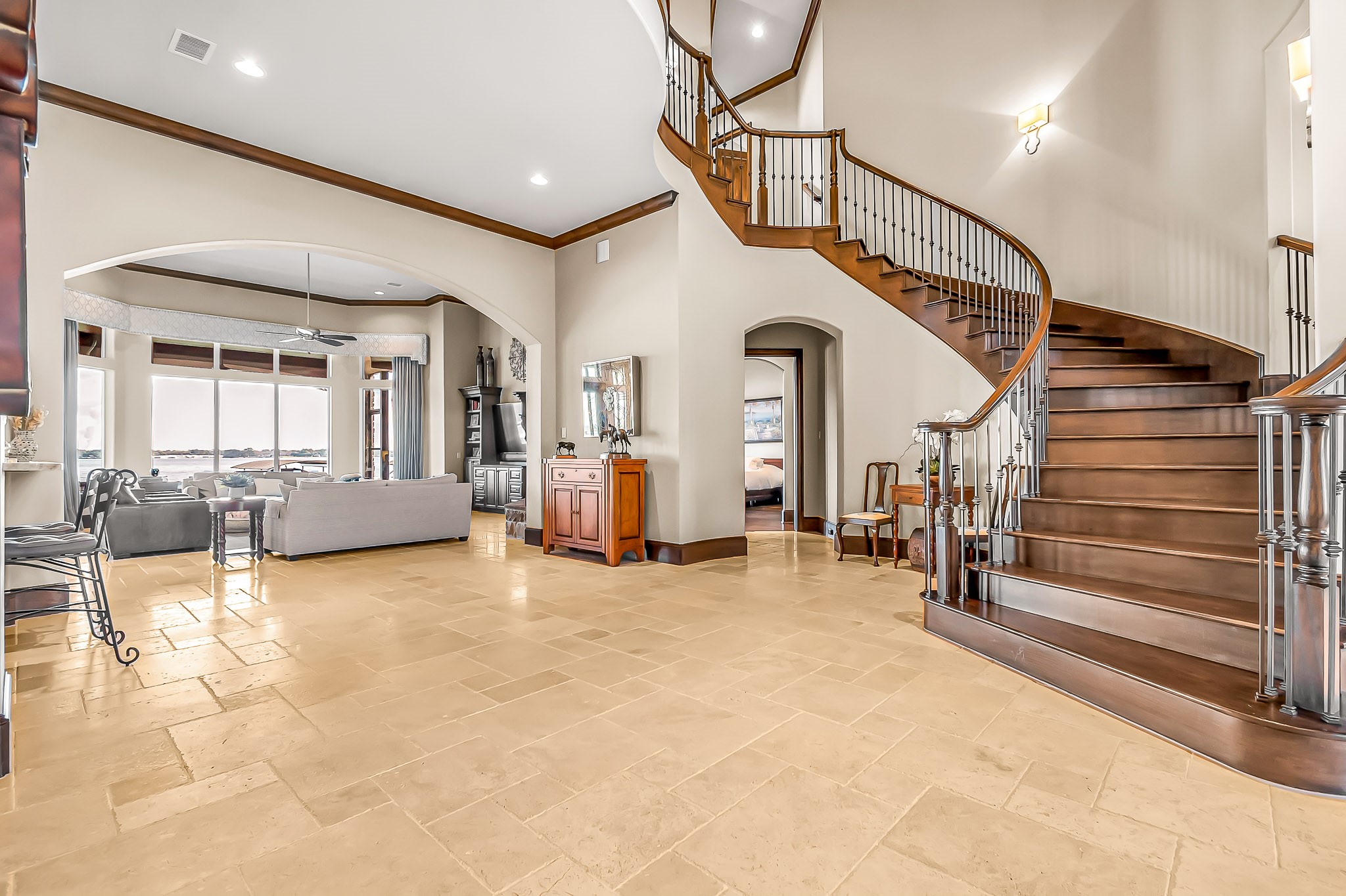 You are greeted by extensive water views upon entering the home. It was designed with a grand entry way to welcome your guests. There is a captivating hallway to the left with sconces and a custom pearl finish ceiling.