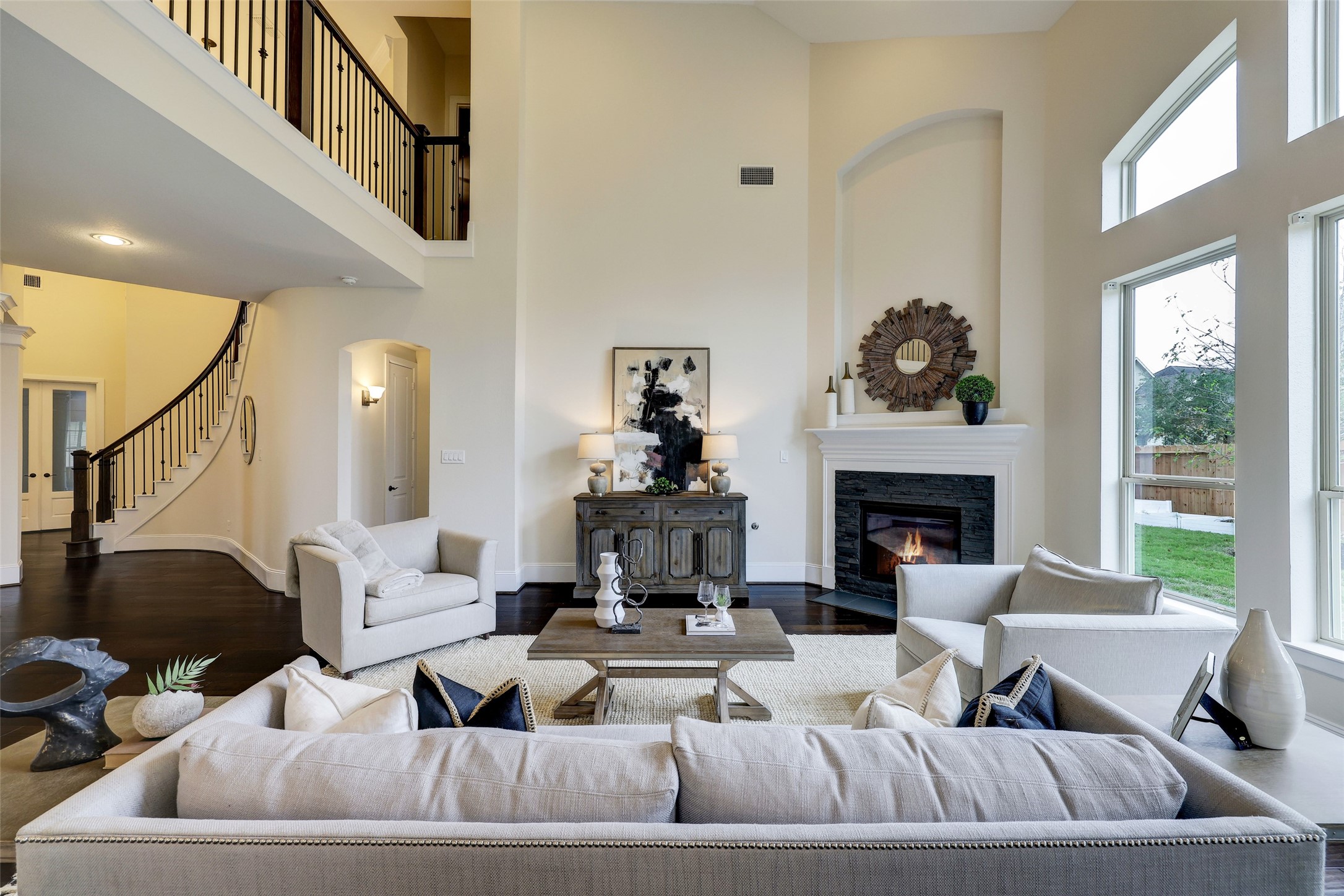 Architecturally interesting niches mimic the tall 2-story window and carry throughout the living room, with an elegant fireplace mantel at its helm.