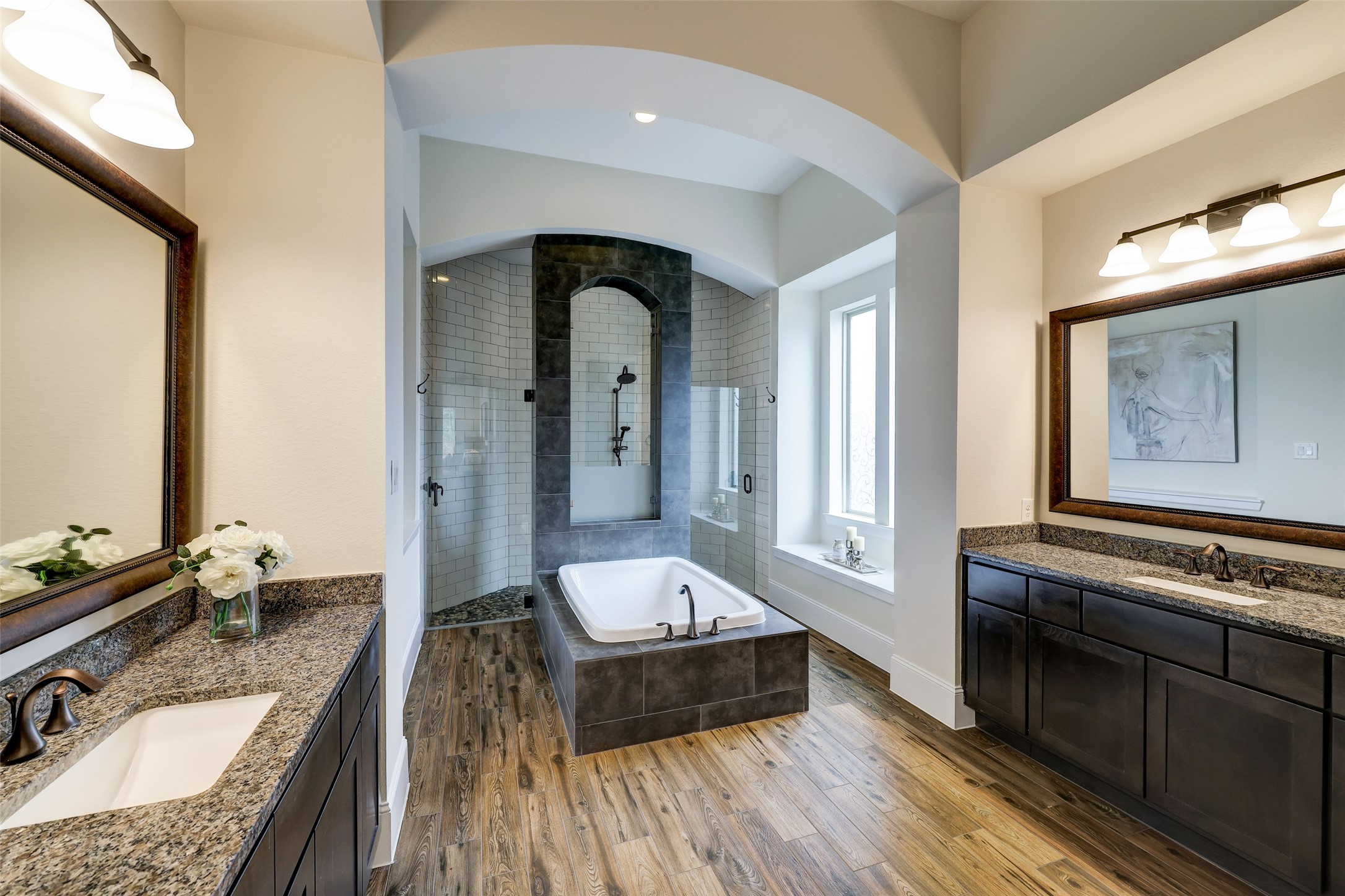 Experience spa-like luxury in the ensuite, featuring dual vanities, a soaking tub, and a frameless dual shower for a daily escape.