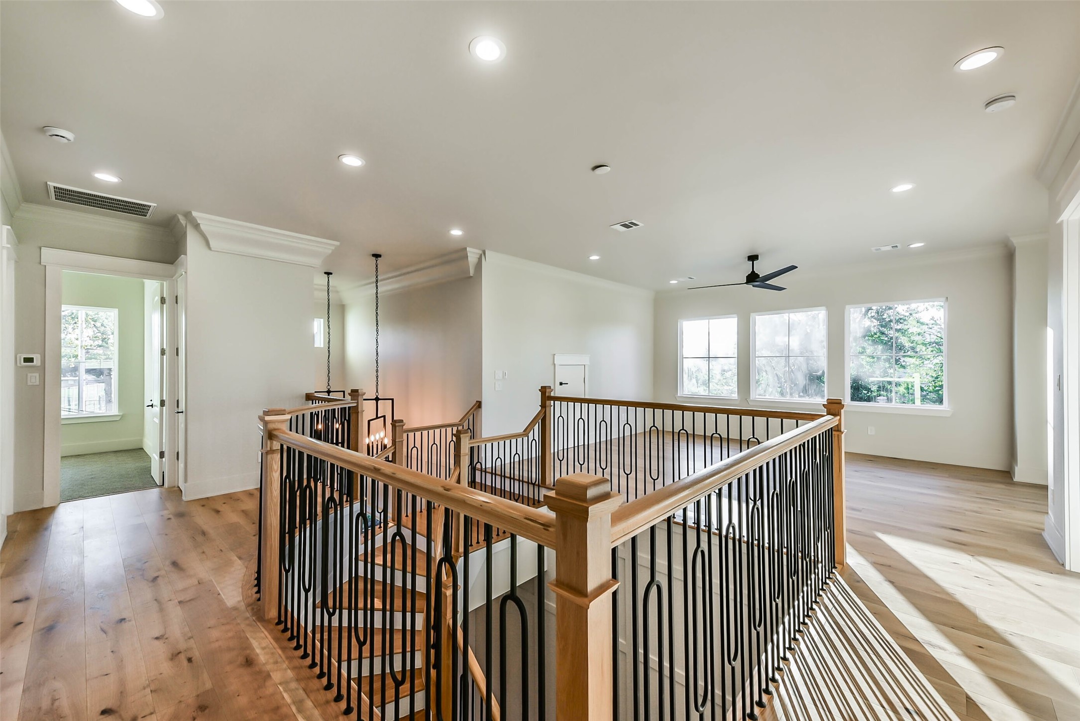 The upstairs hall and game room have wide plank white oak floors and large windows allowing natural light to flow throughout the space.