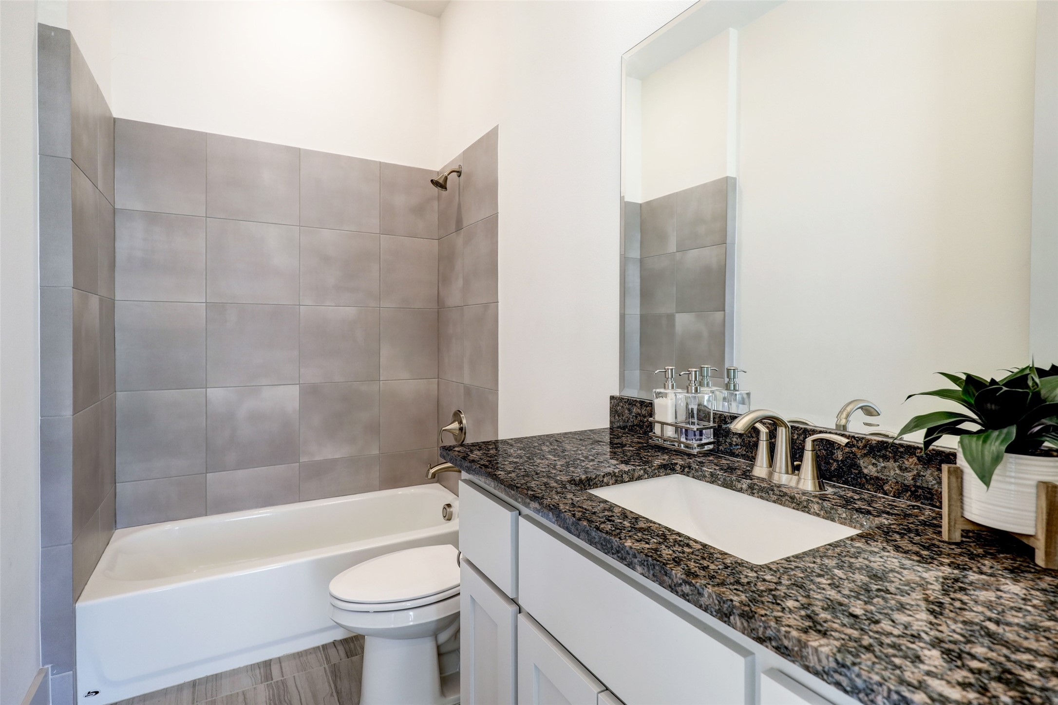 The first-floor full bath, strategically positioned near the movie room, offers flexibility and convenience for various uses. This well-appointed bathroom includes a bath/shower combination, an undermount sink, and nickel fixtures, providing both style and functionality for residents and guests alike. Its accessible location adds practicality to the overall design of the home.