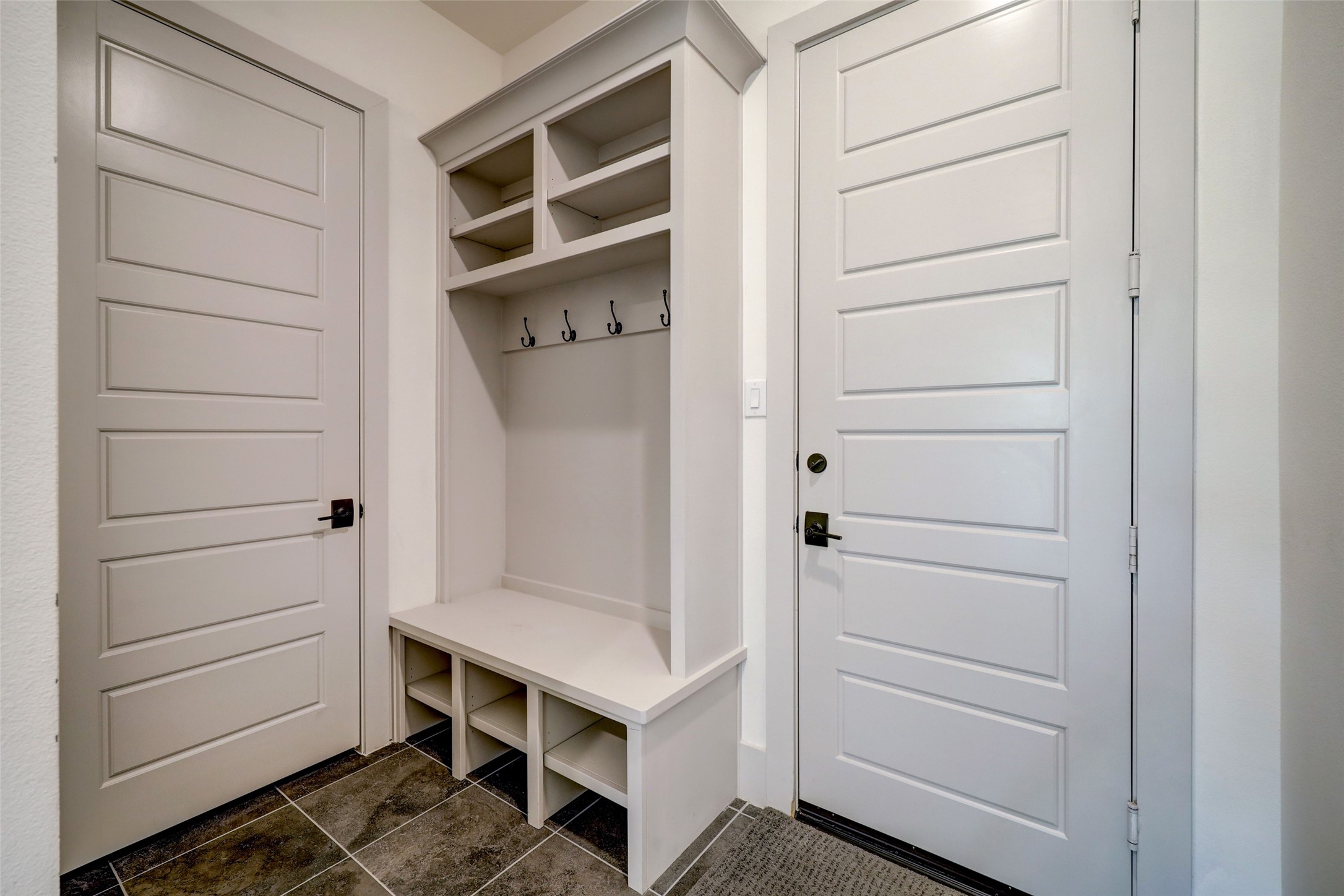 Effortlessly maintain order in the mudroom, designed as the perfect space for unloading bags, backpacks, and shoes. Multiple cubbies and hooks offer a systematic approach to organization, ensuring each item has its designated place for easy access. This thoughtfully arranged mudroom not only streamlines daily routines but also enhances the overall functionality of the home.