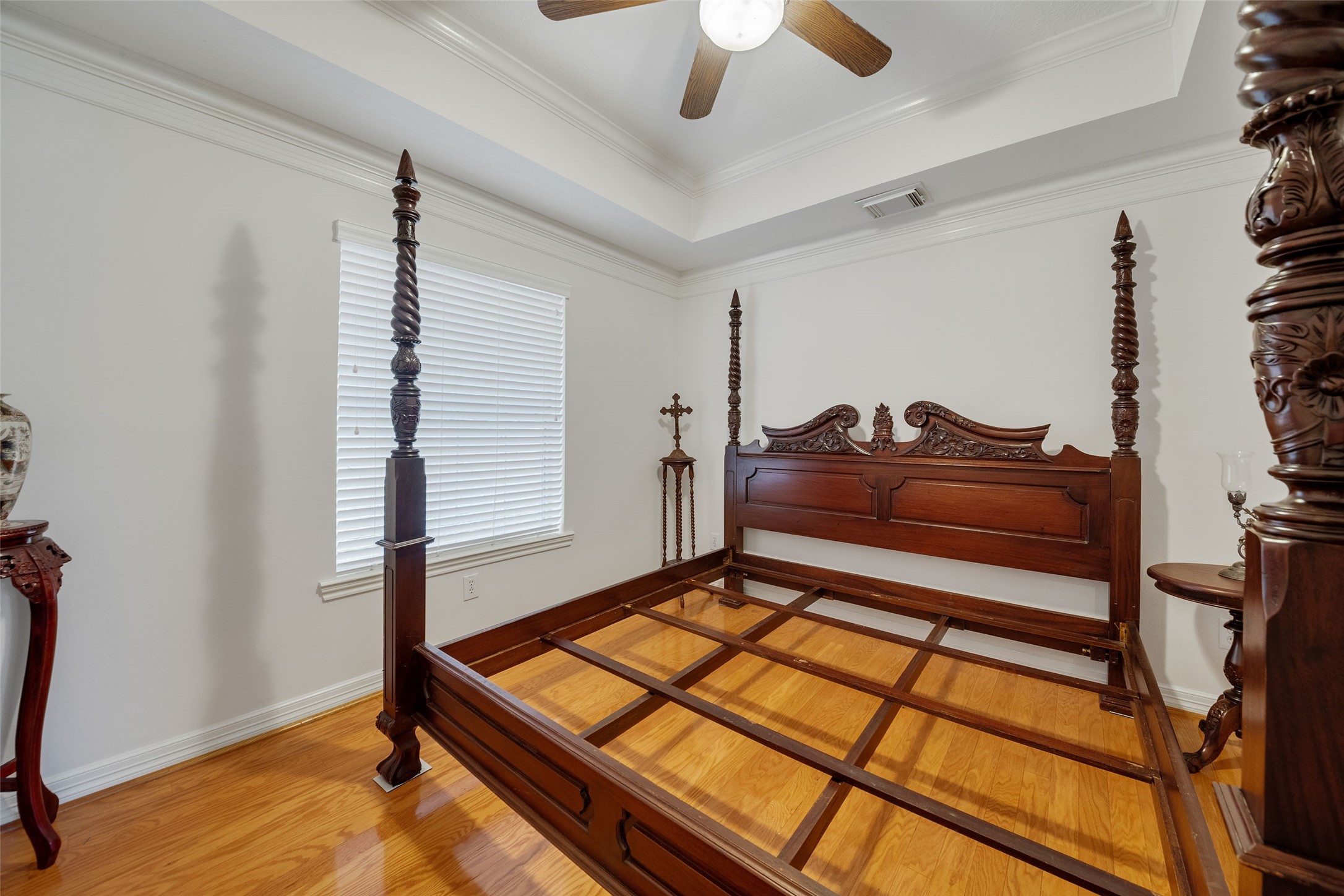 Third guest bedroom has tray ceiling, wood floors and crown molding.
