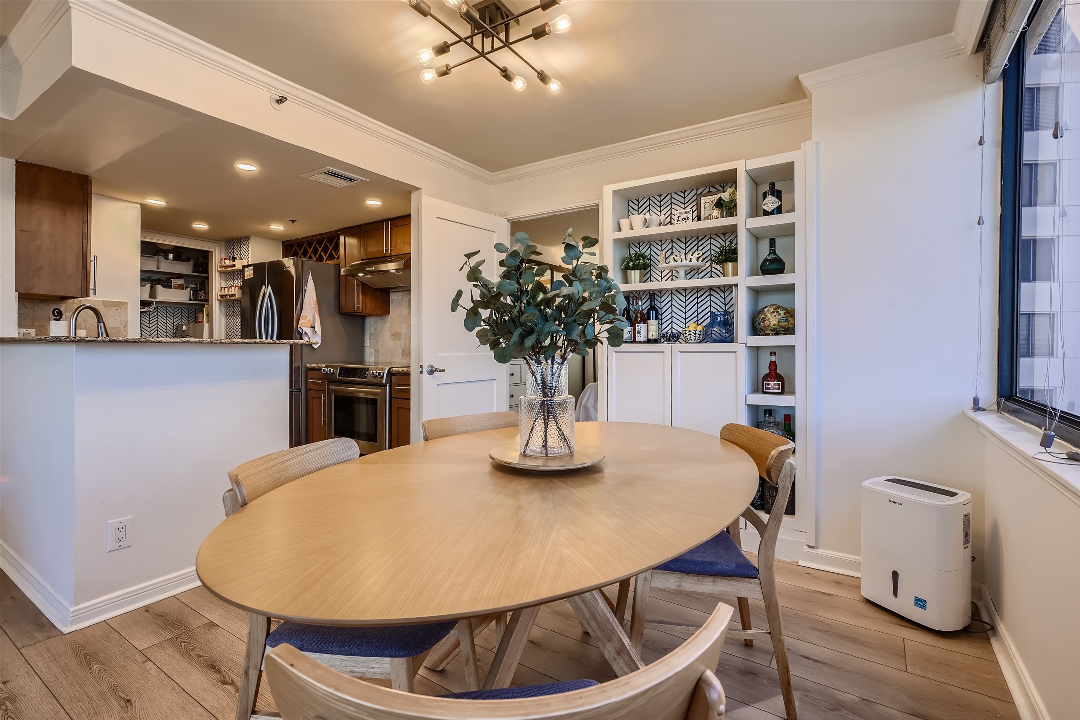 Capture the seamless flow from the kitchen to the dining room, with a view showcasing a custom-built cabinet. This thoughtful addition provides practical storage and an elegant display for décor.