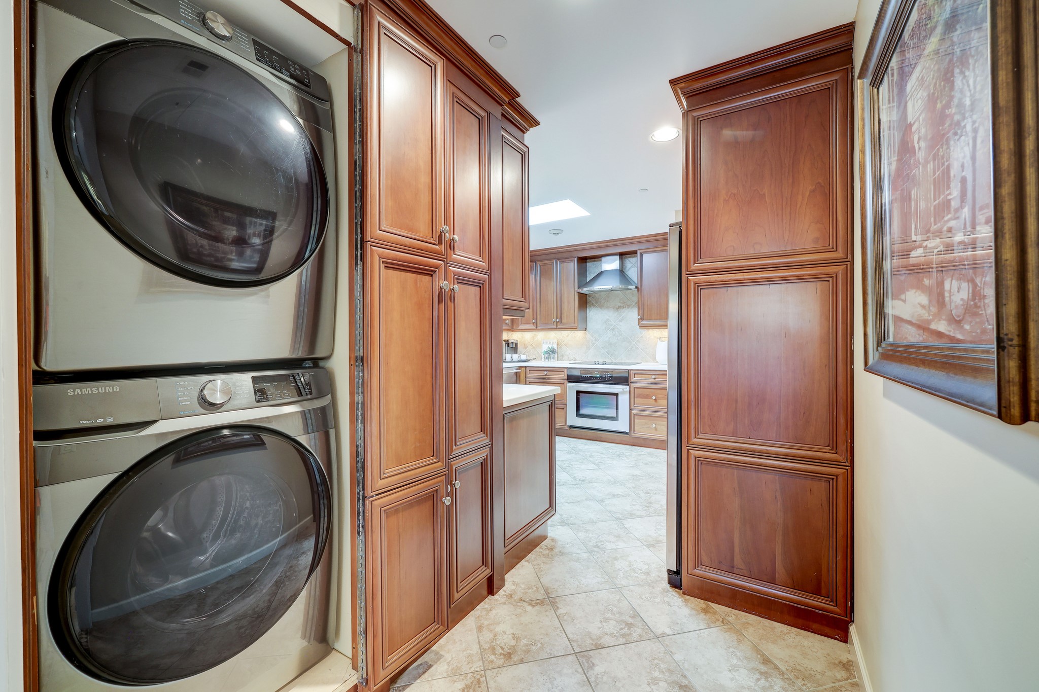 Stackable washer and dryer at entry of kitchen.