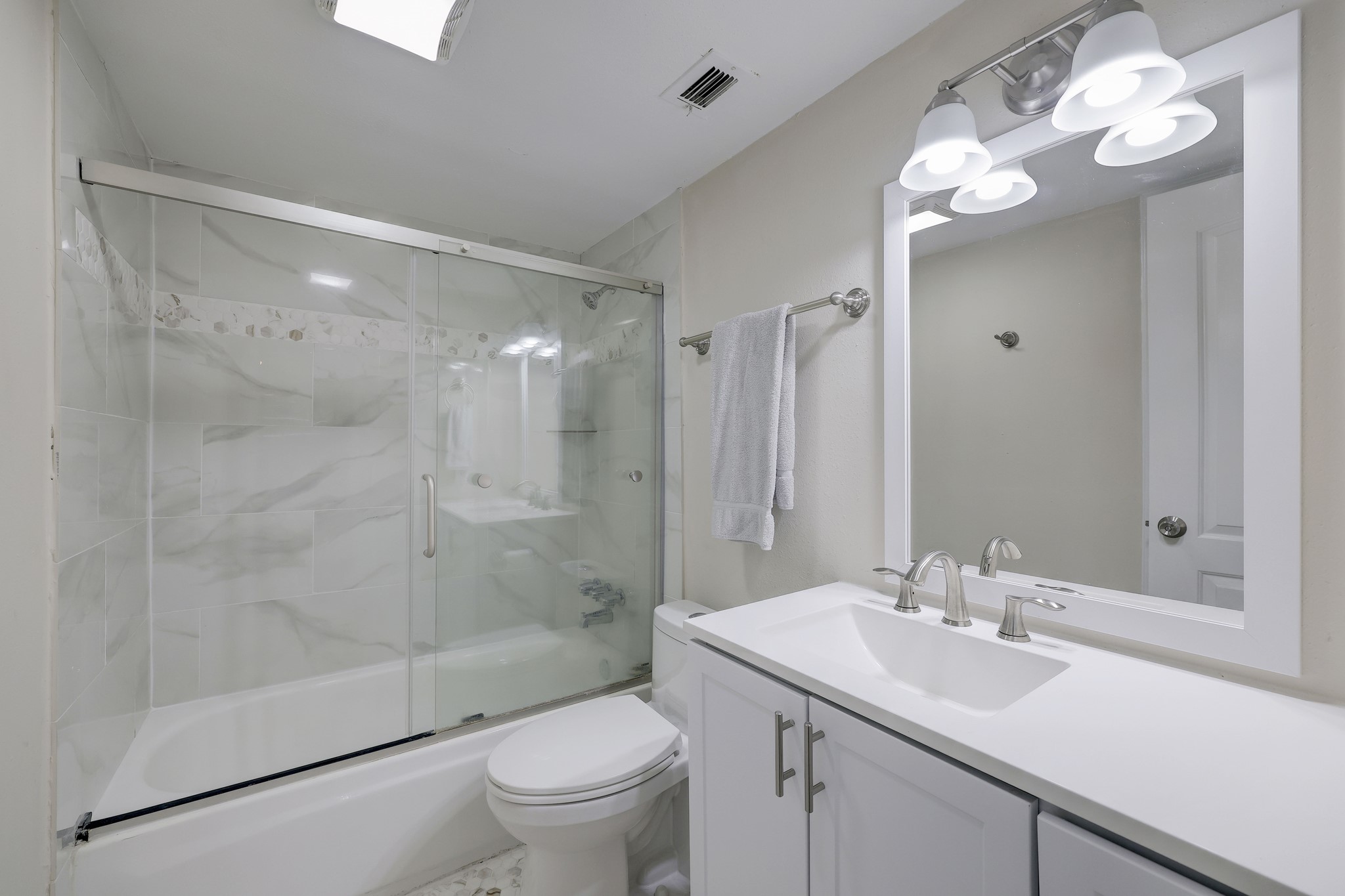 Glass enclosed tub/shower and lovely shower backsplash for easy cleaning