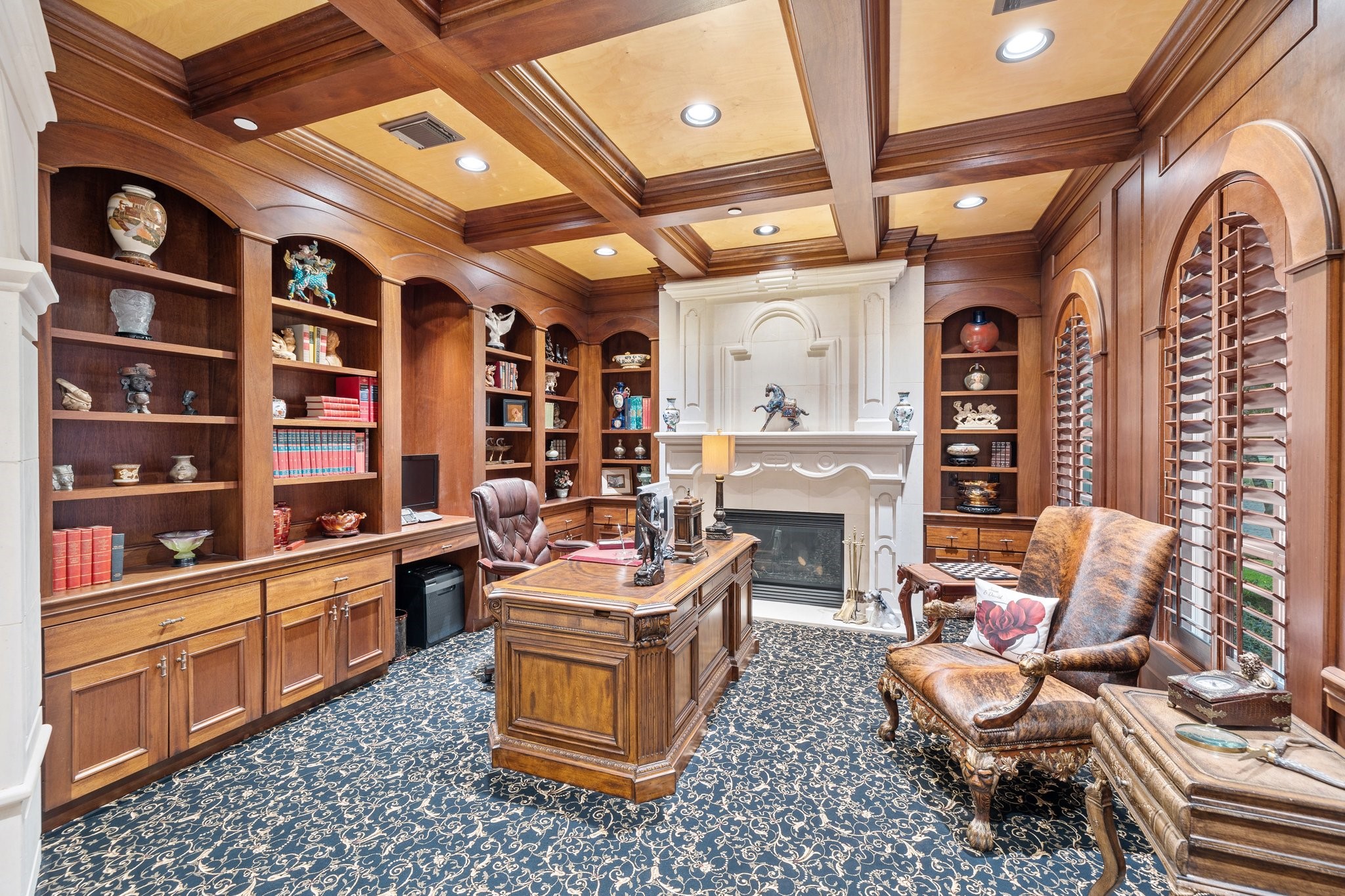 Step into the study, a space that exudes sophistication and warmth. Limestone accents and a cozy fireplace create a commanding, yet inviting atmosphere. The dark wood shelving provides ample room for your personal library or to showcase your prized collectibles.