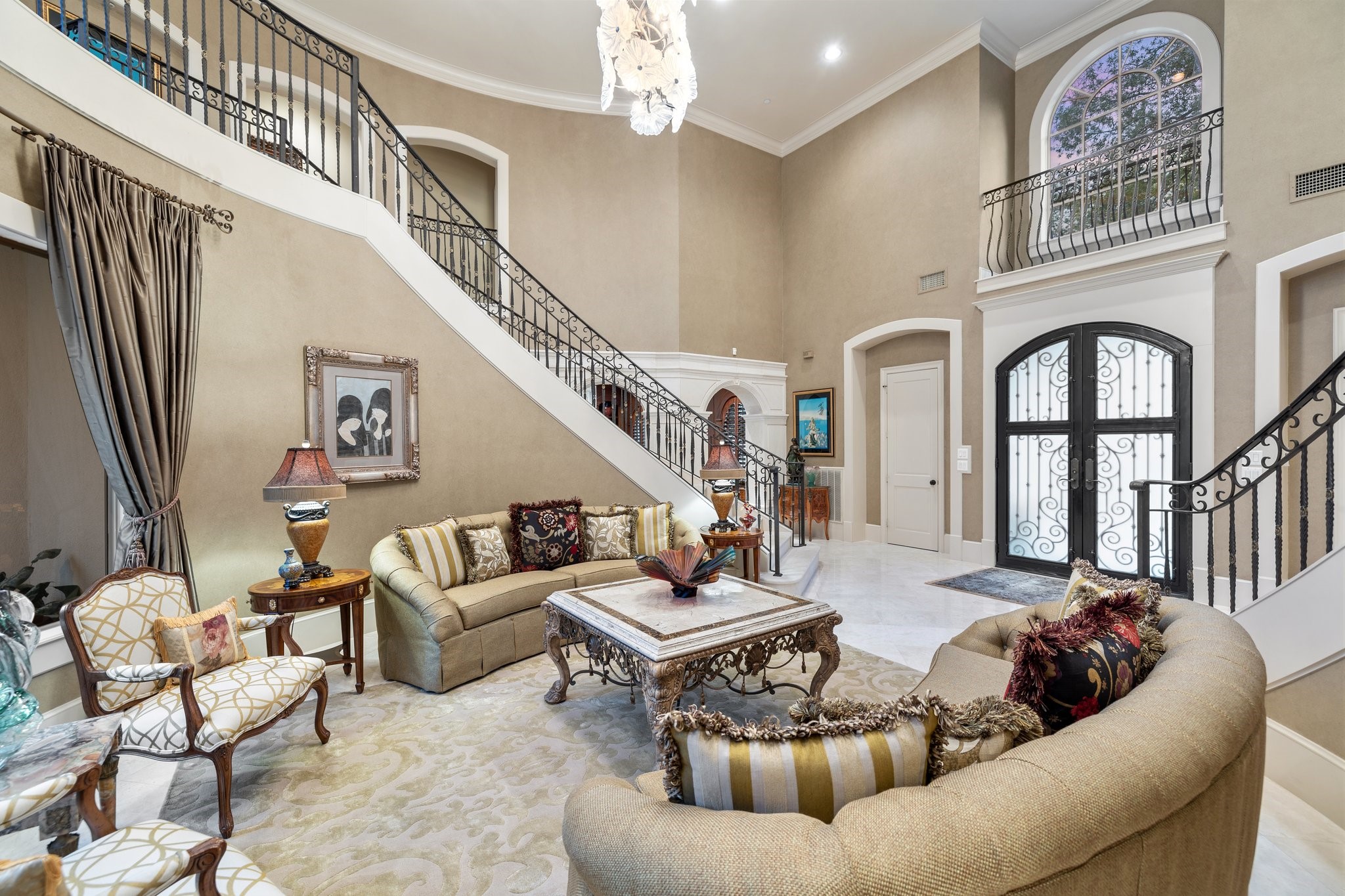 Enjoy the luxurious formal living room with grand windows and marble floors.