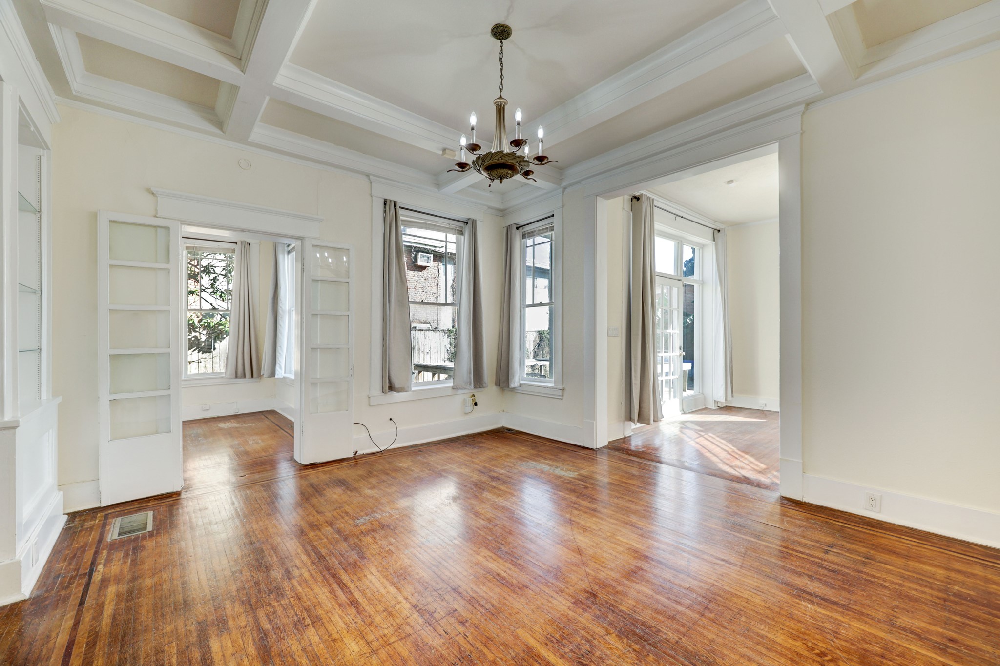 A view of the formal dining area.  Complete with coffered ceilings, built-ins and original hardwood floors.