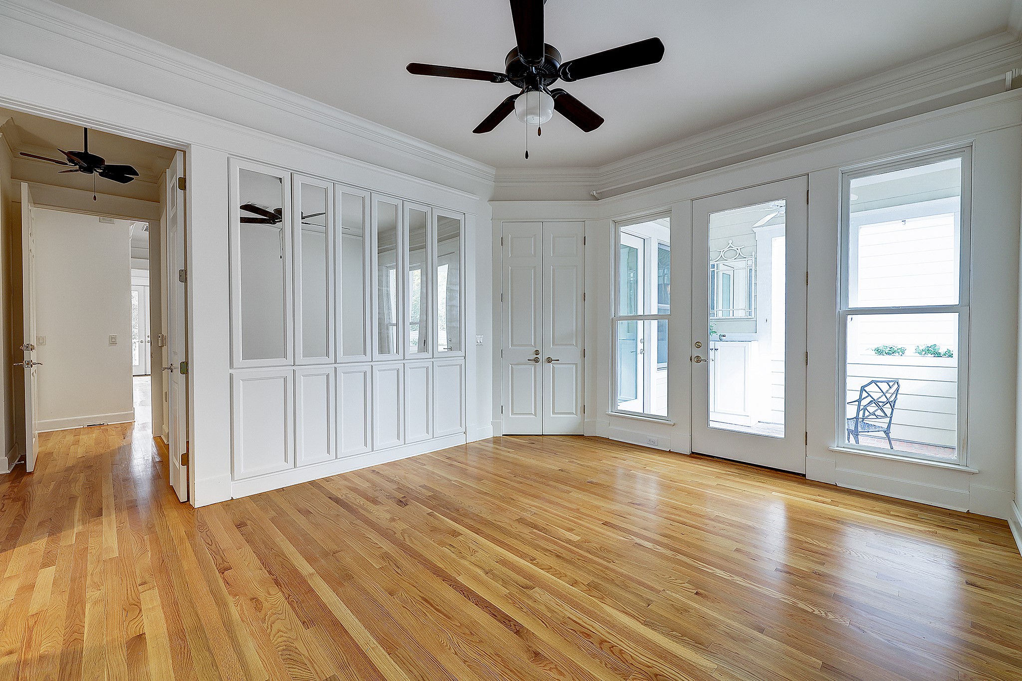 The wood floors continue into the bedrooms, including this spacious primary bedroom. Plenty of room and with so many built-ins, you don't need much furniture.(virtually staged)