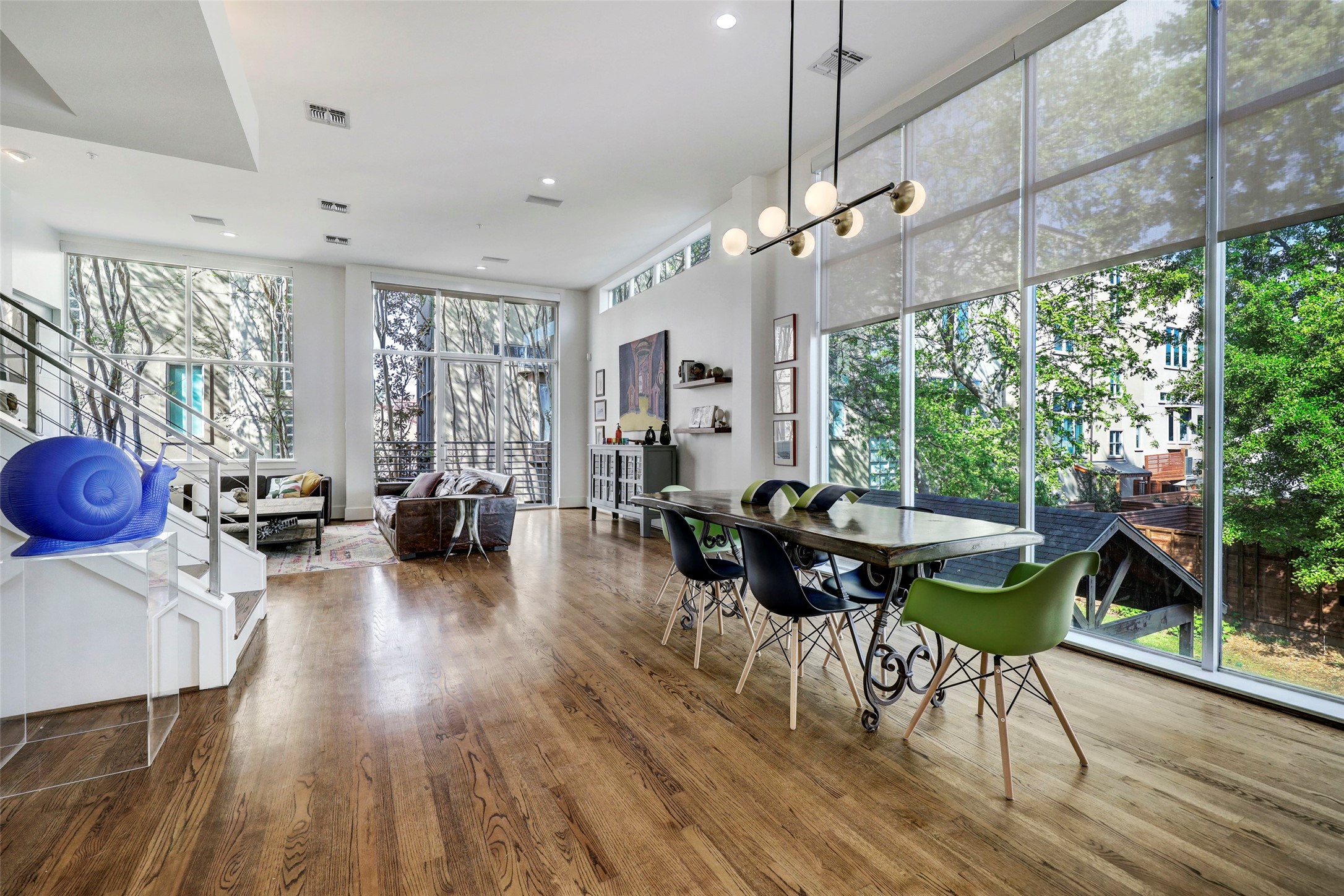 dining area open to living room floor to ceiling windows