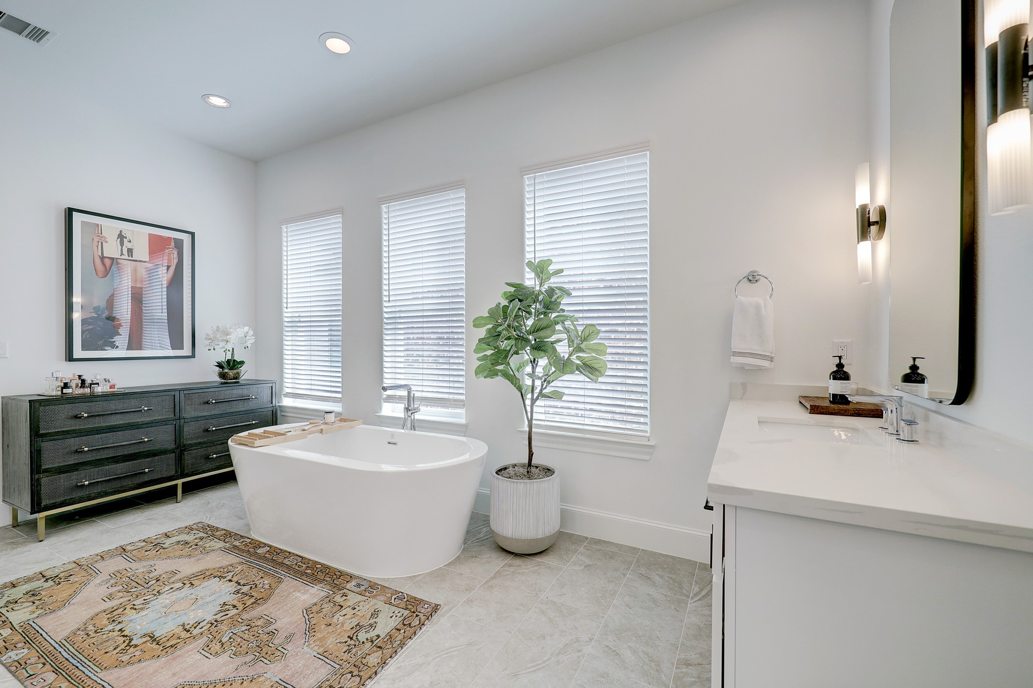 The primary ensuite features a tranquil soaking tub and dual vanities, including a makeup vanity to the right.