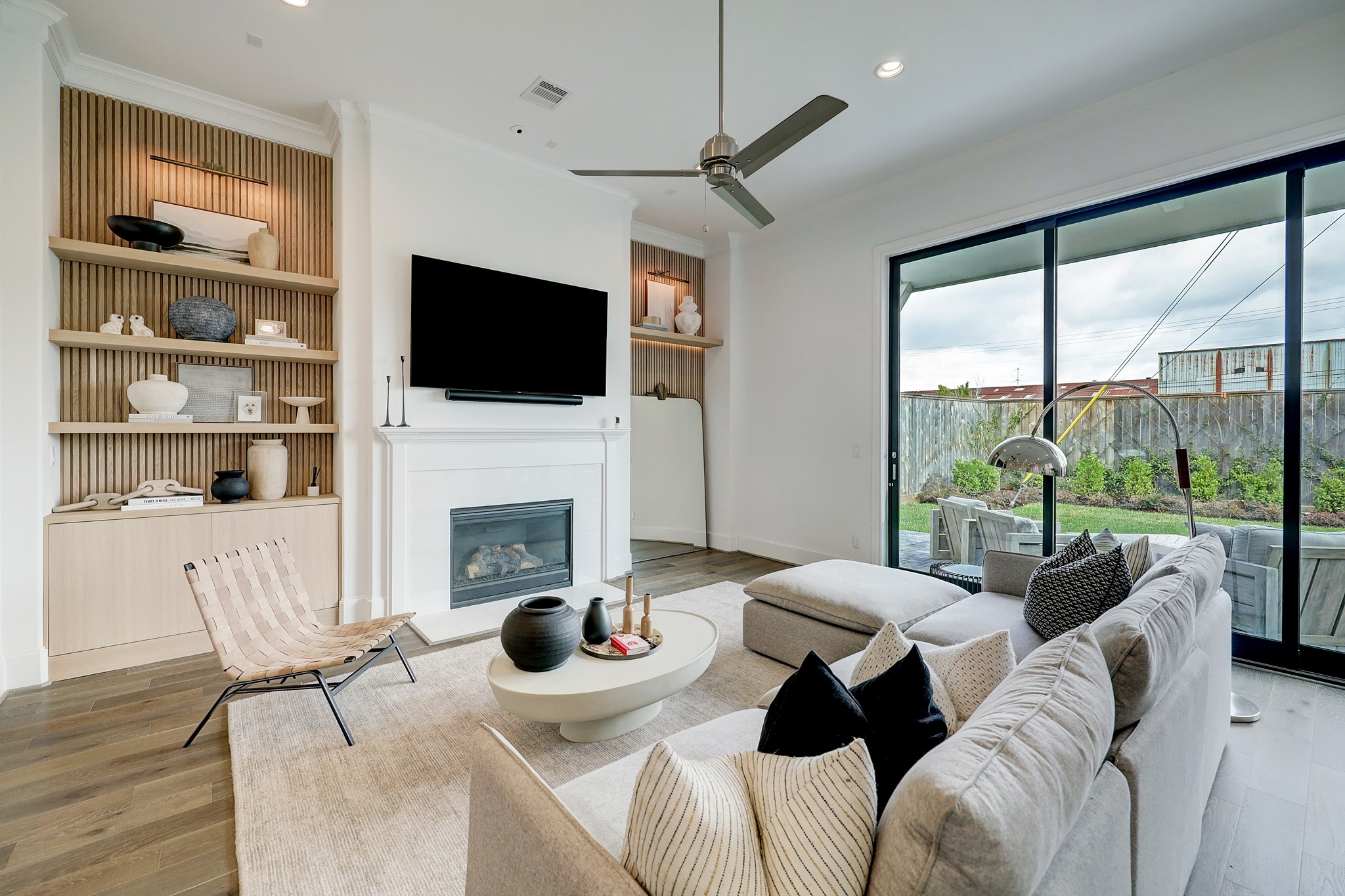 The spacious living room features a fireplace, custom built-ins and sliding glass doors.