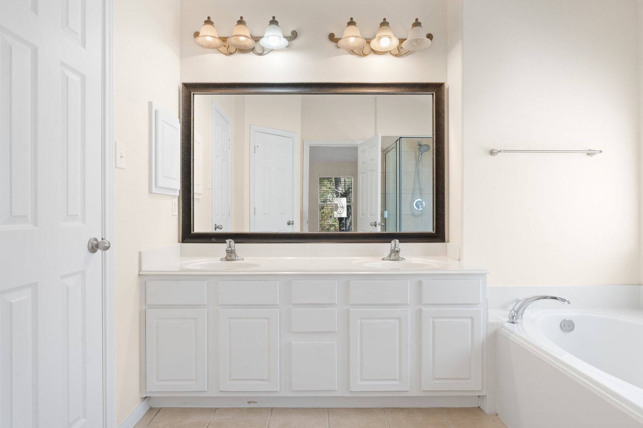 The primary bath offers a double vanity with a full size mirror!