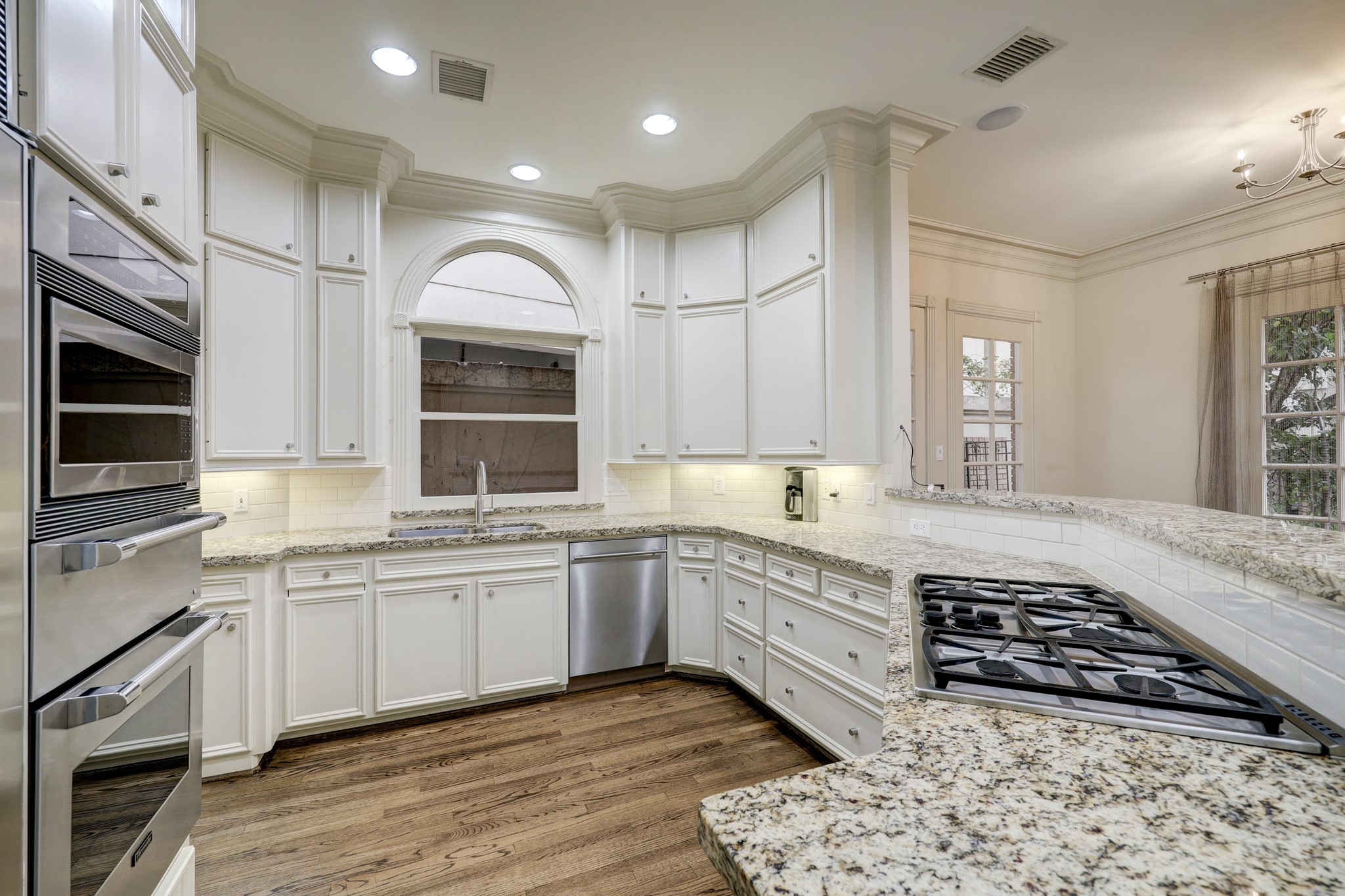 the large kitchen offers double ovens and a gas range and bar seating.