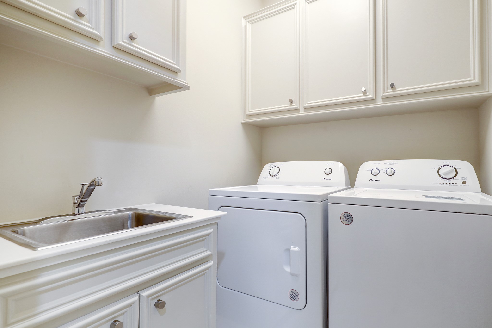 The nice sized laundry rooms offers ample storage ad a large stainless soaking sink.