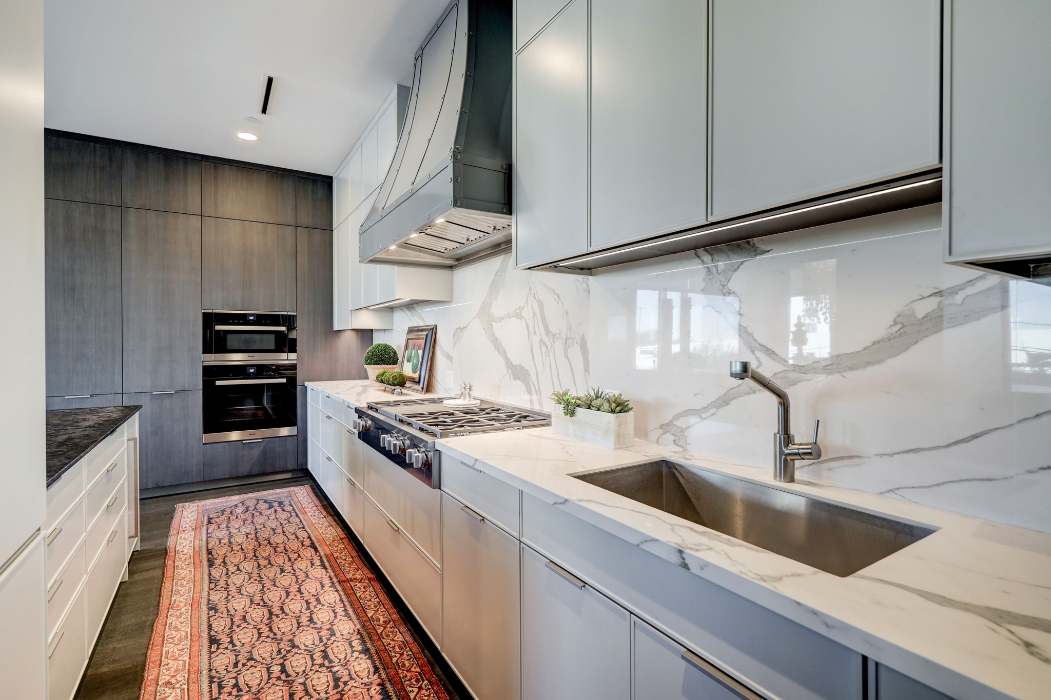 Quartzite counters, oversized sink and cook top with 6 gas burners (highly unusual in a high rise) and griddle, microwave and convection ovens. At the far end of the island is an ice maker. Wall cabinets extend to the ceiling to maximize storage.