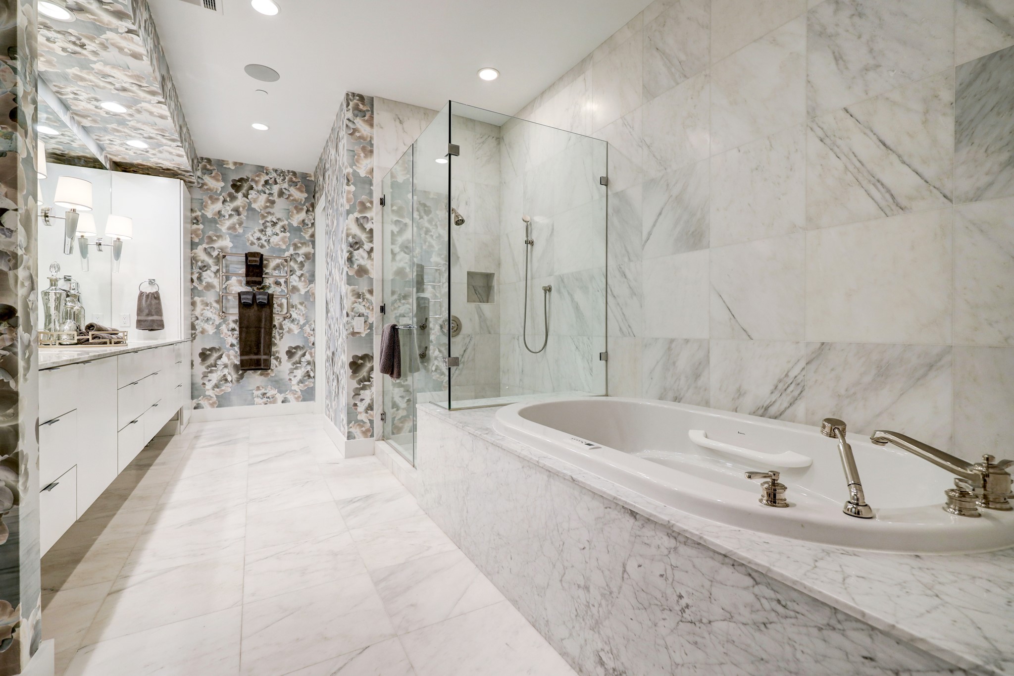 Elegant primary bath with oversized soaking tub, huge shower, dual vanities and custom designer wall paper.