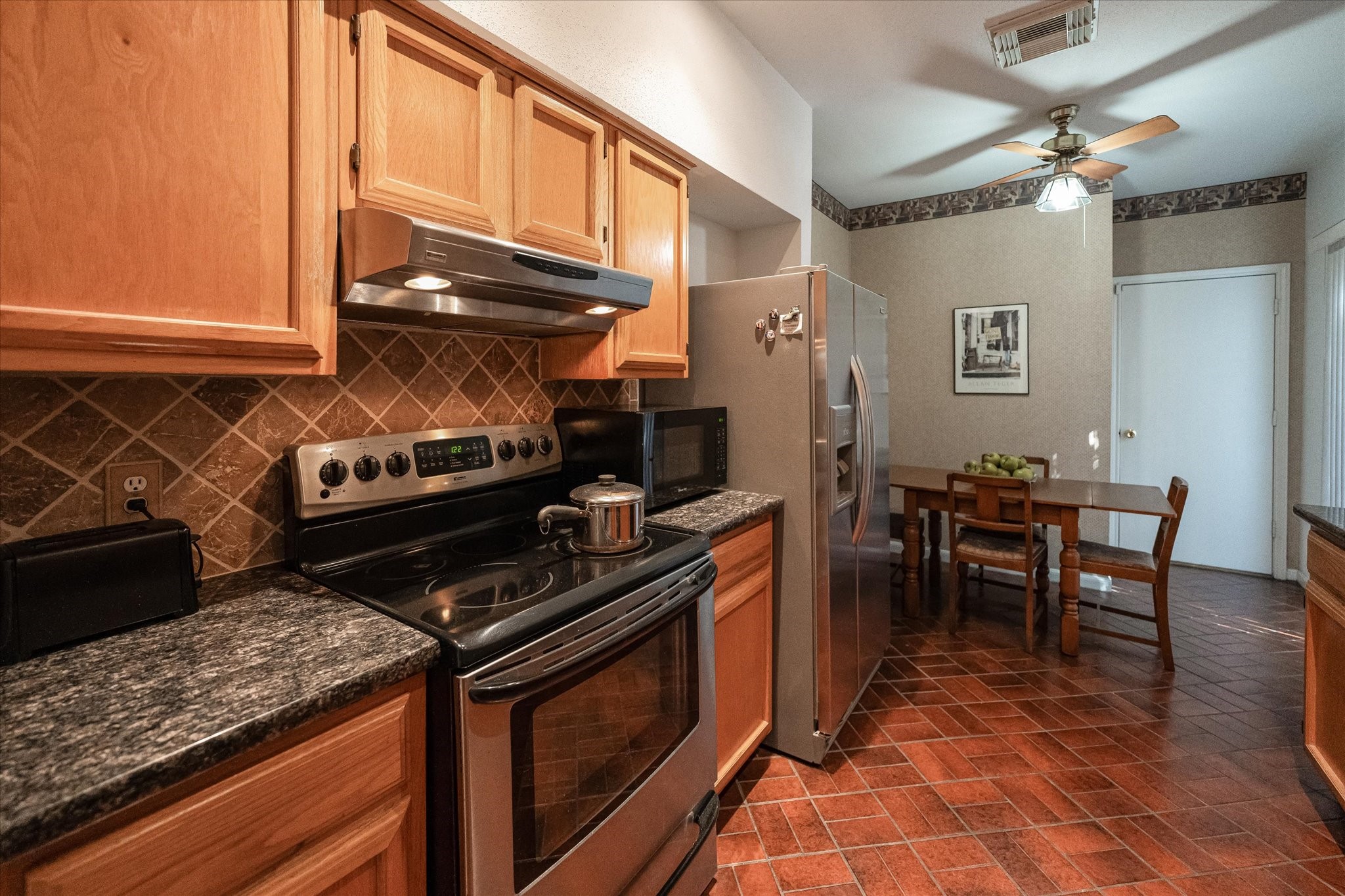 Diving in closer to your kitchen, overlooking the breakfast area. This space is gorgeous and comes equipped with stainless steel appliances, granite counter tops, beautiful cabinetry, and tile flooring.