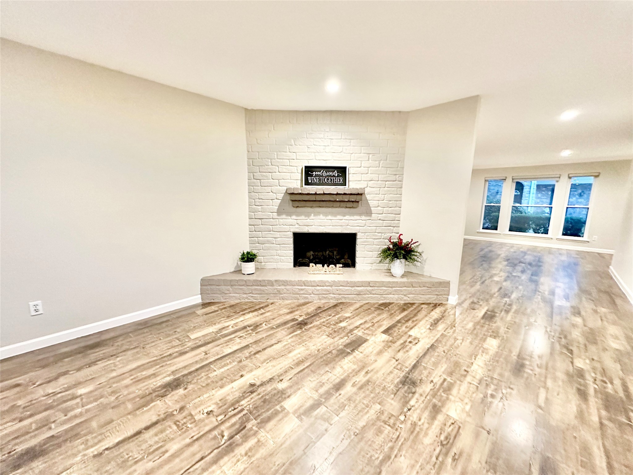Wide laminate floor paths and unobstructed space from family room to dining and living room area over looking recently updated double pane windows with blackout roller shades.