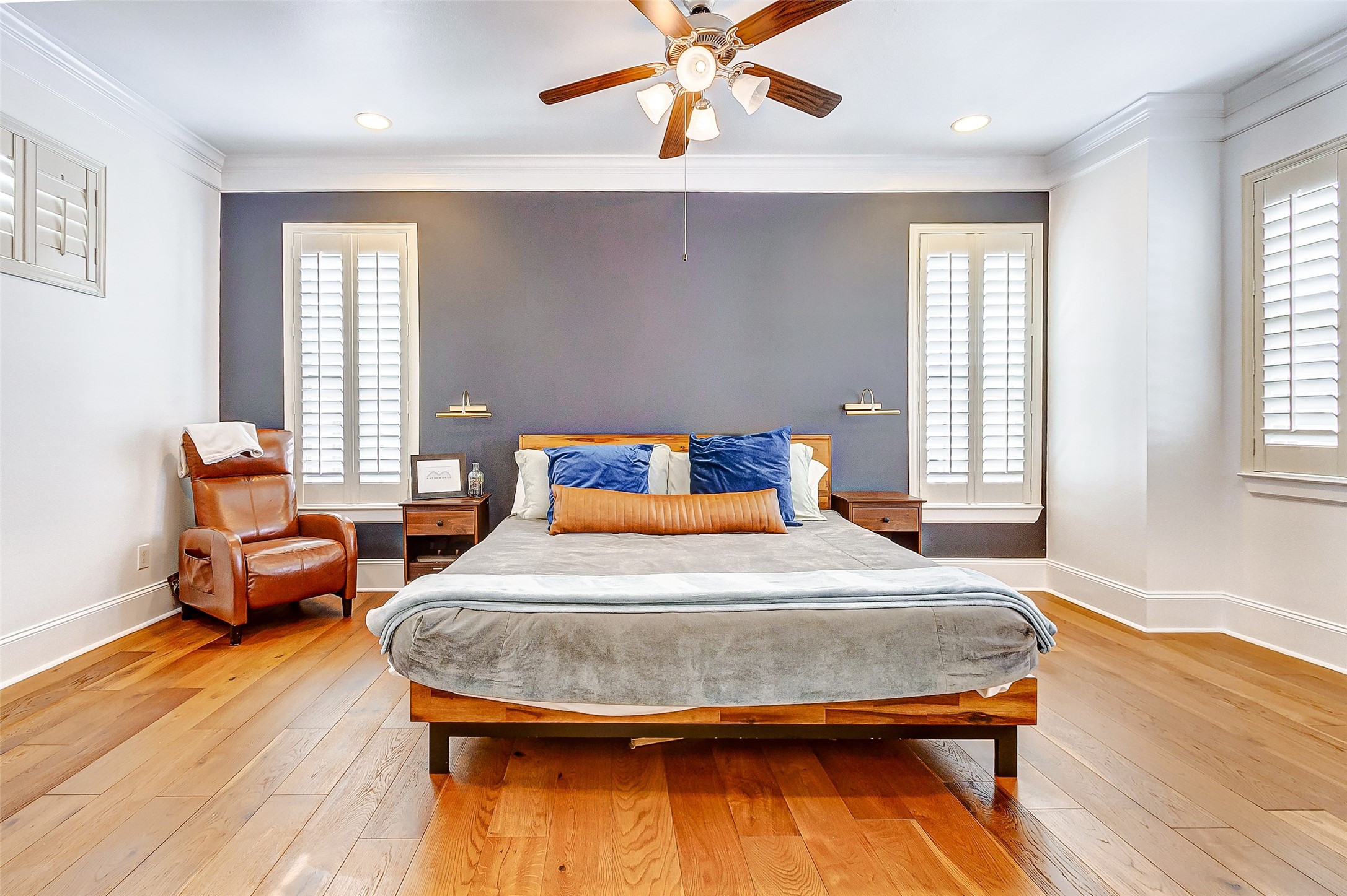 Welcome to your lovely primary suite atop the third floor offering plentiful views, an abundance of natural lighting, gorgeous wood flooring, designer accent wall, crown-molding, plantation shutters, and your own private bathroom.