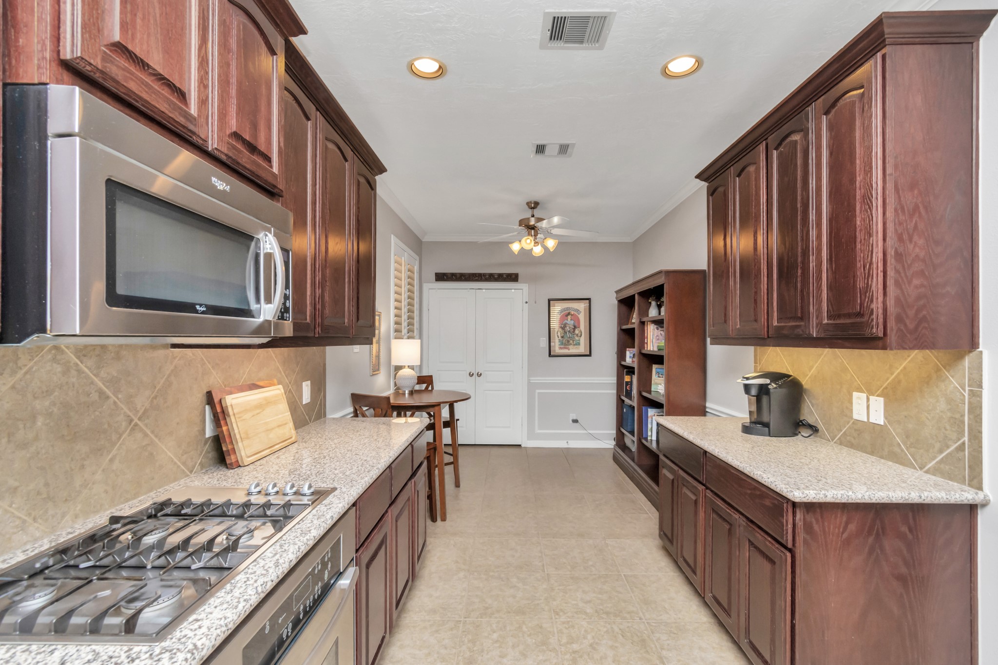 At the far end of the kitchen, a sizable double-door pantry awaits, offering extensive storage for your essentials.