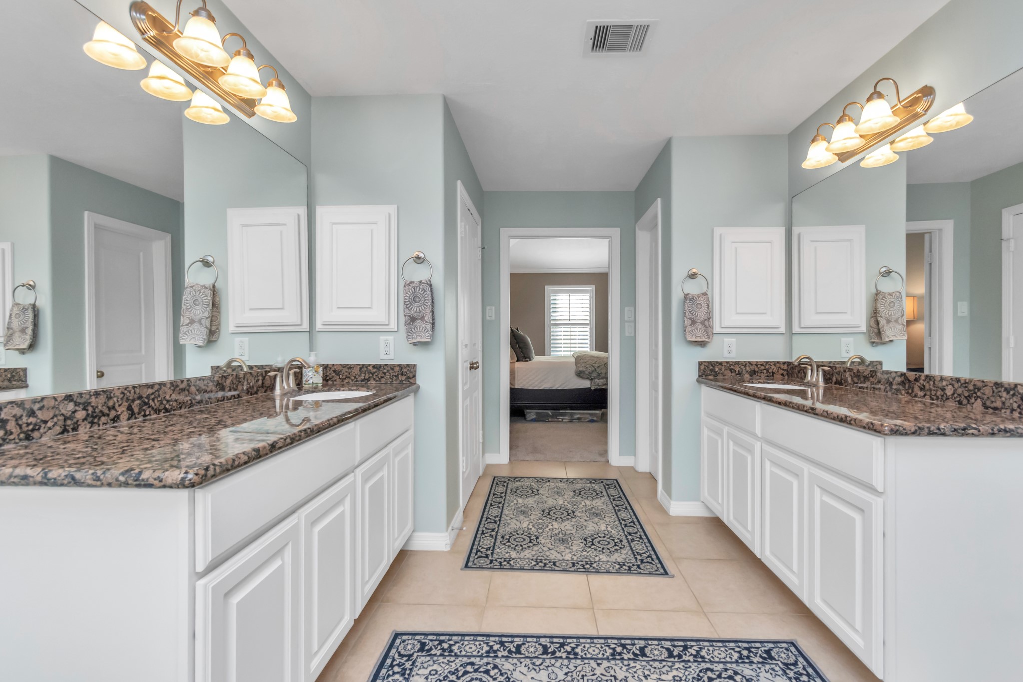 Dual sinks adorned with granite counters ensure ample space for everyone's needs.