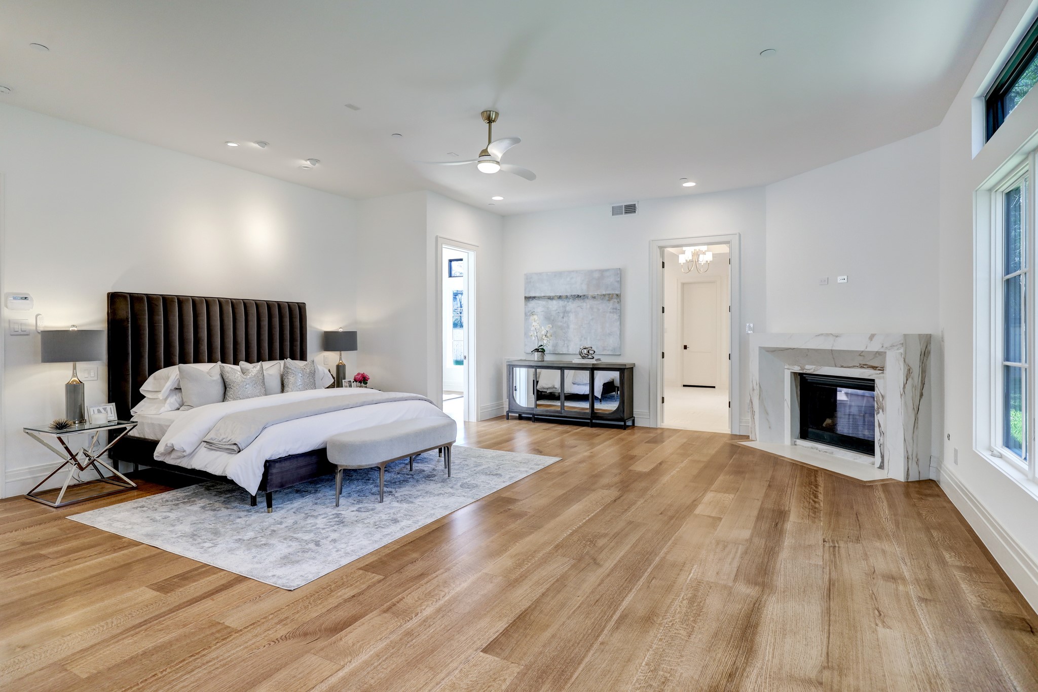 Primary bedroom suite is spacious and cozy with a stunning corner fireplace, lovely windows and an attached sitting area and separate home office/study. The honeyed French Oak floors shine.