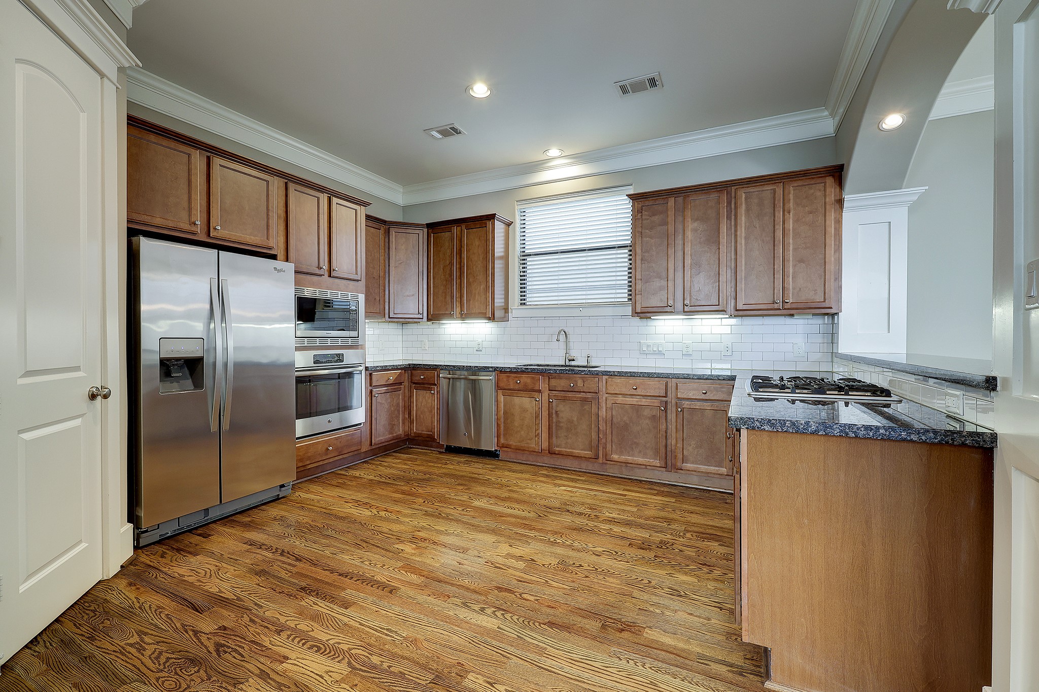 This glamorous kitchen shines with hardwood floors, stainless steel appliances, large pantry and crown molding (refrigerator stays with home).