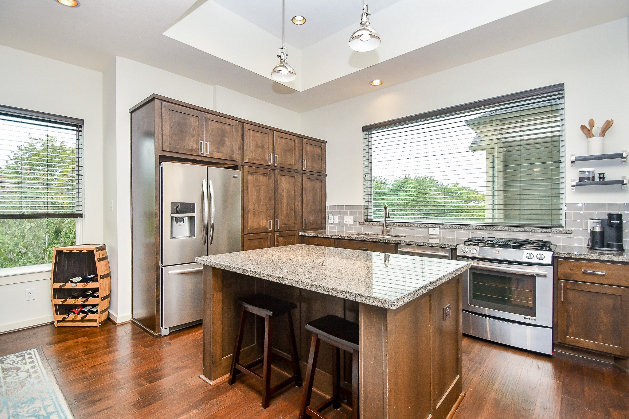 The kitchen features a huge island, tons of cabinetry storage and sleek stainless steel appliances.