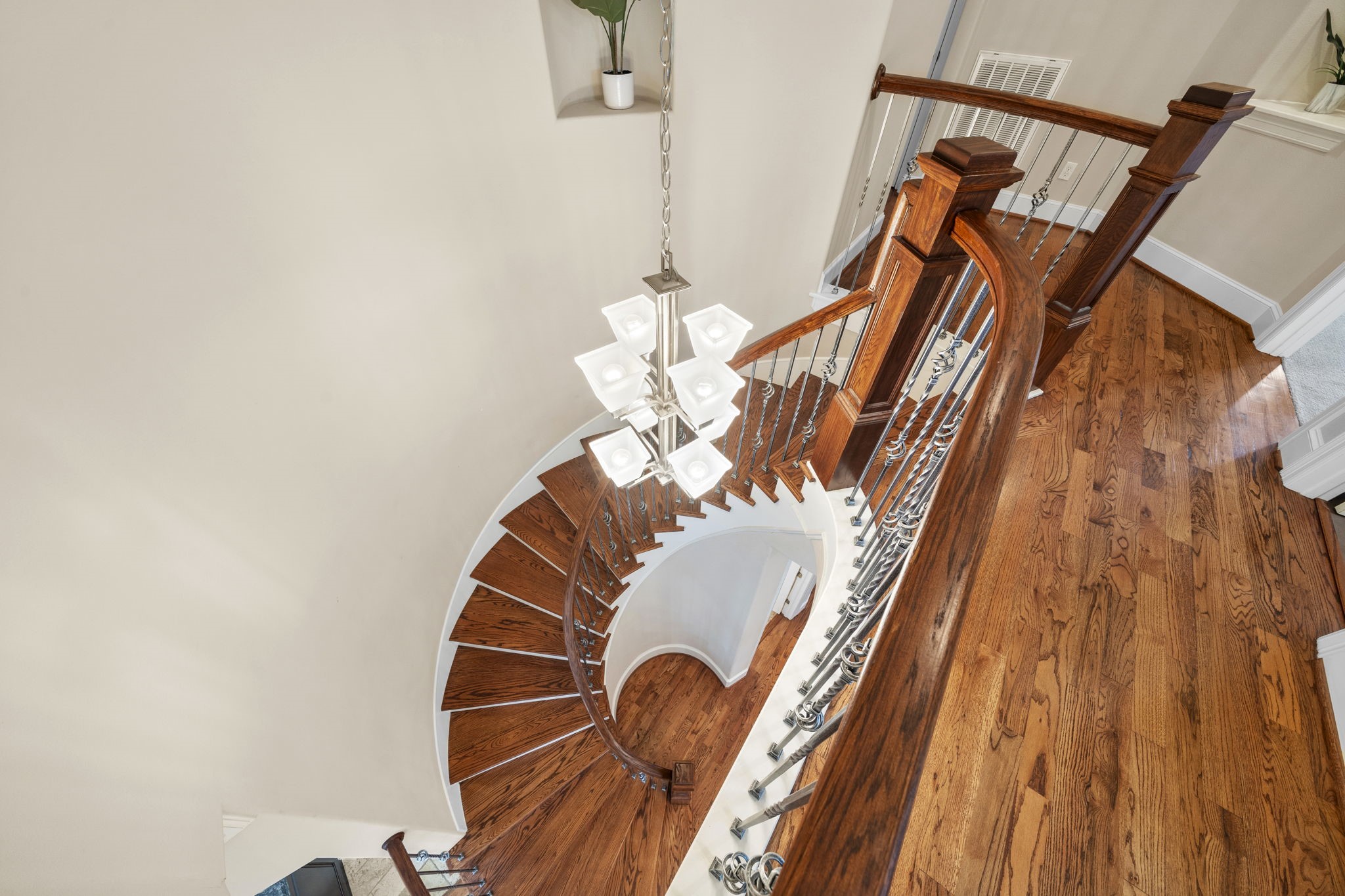 Easily reached from the formal dining room and upstairs hallway, the spiral staircase is adorned with wrought-iron spindles and wooden handrails, seamlessly blending with lustrous hardwood floors that continue throughout the second floor.