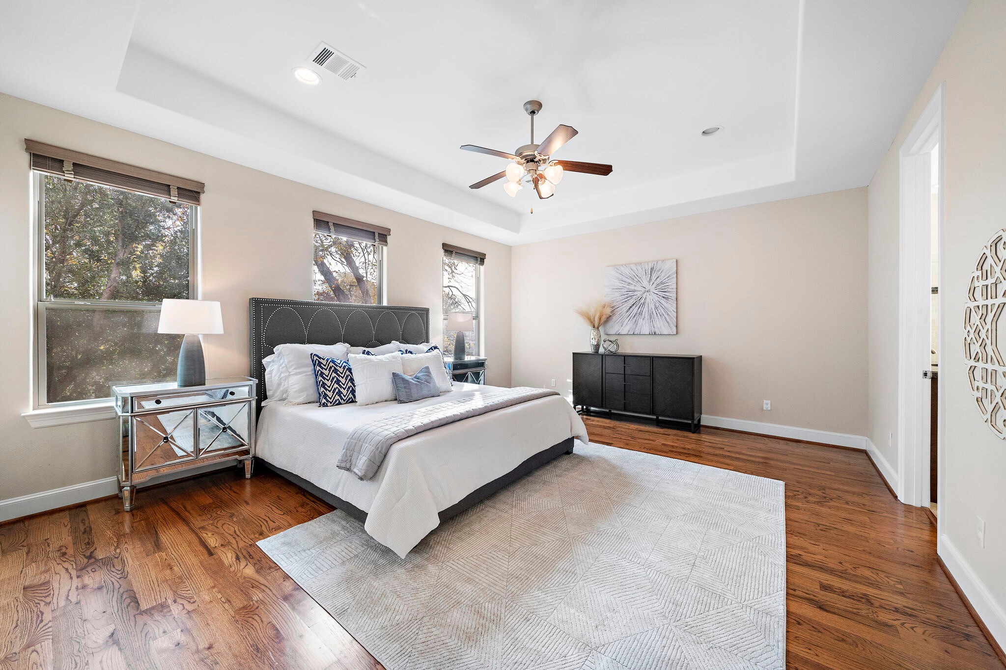 Made for ultimate comfort, the primary suite offers ample floor space, multiple windows overlooking lush neighborhood trees, and timeless finishes throughout.