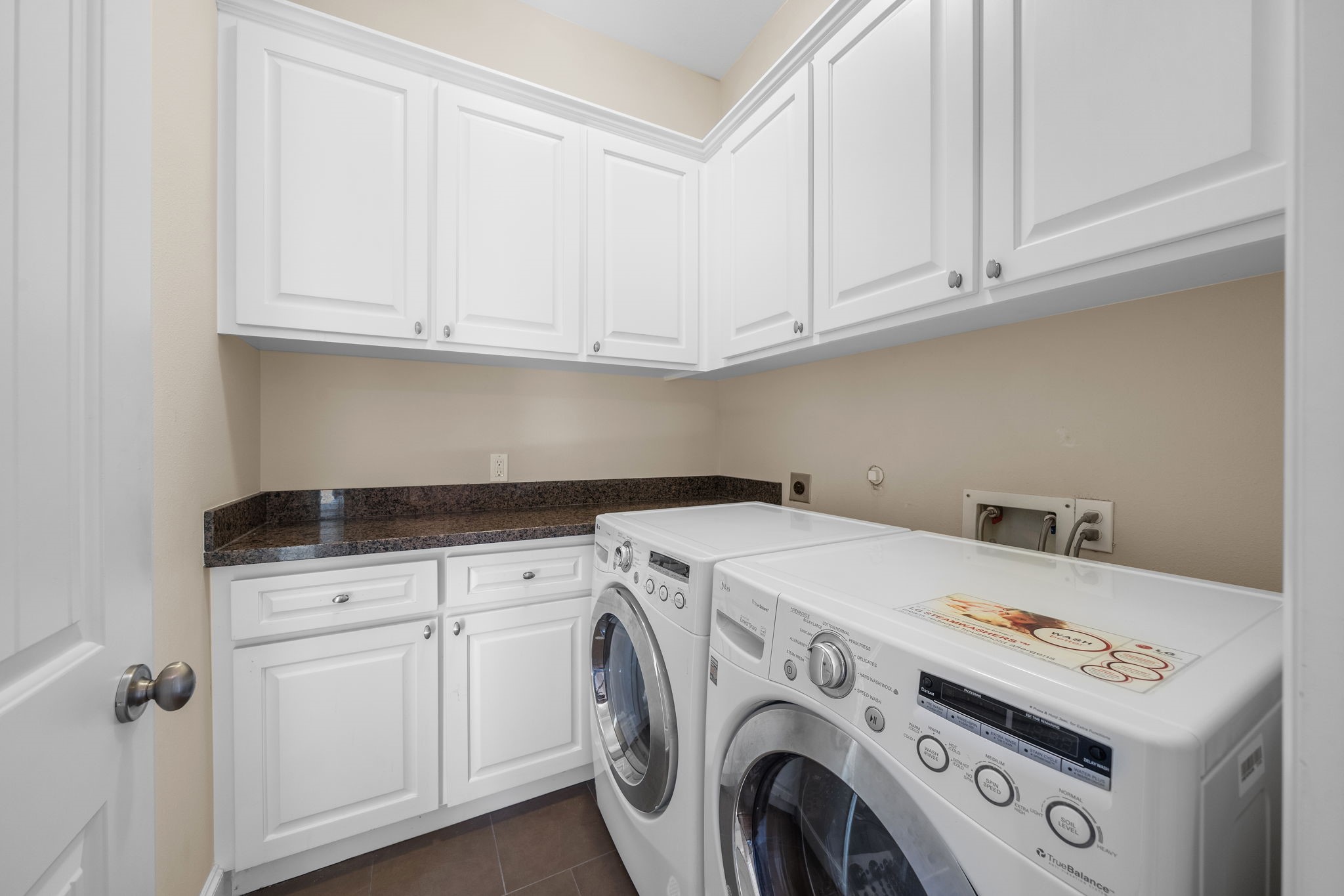 Situated on the second floor, find a laundry room complete with an abundance of built-ins, granite counters, plus an LG dryer and washer.