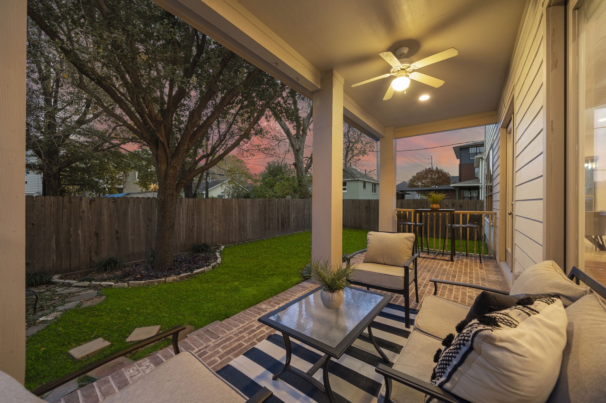 Unforgettable gatherings await in the fully fenced backyard oasis, featuring a brick patio and lush landscaping.