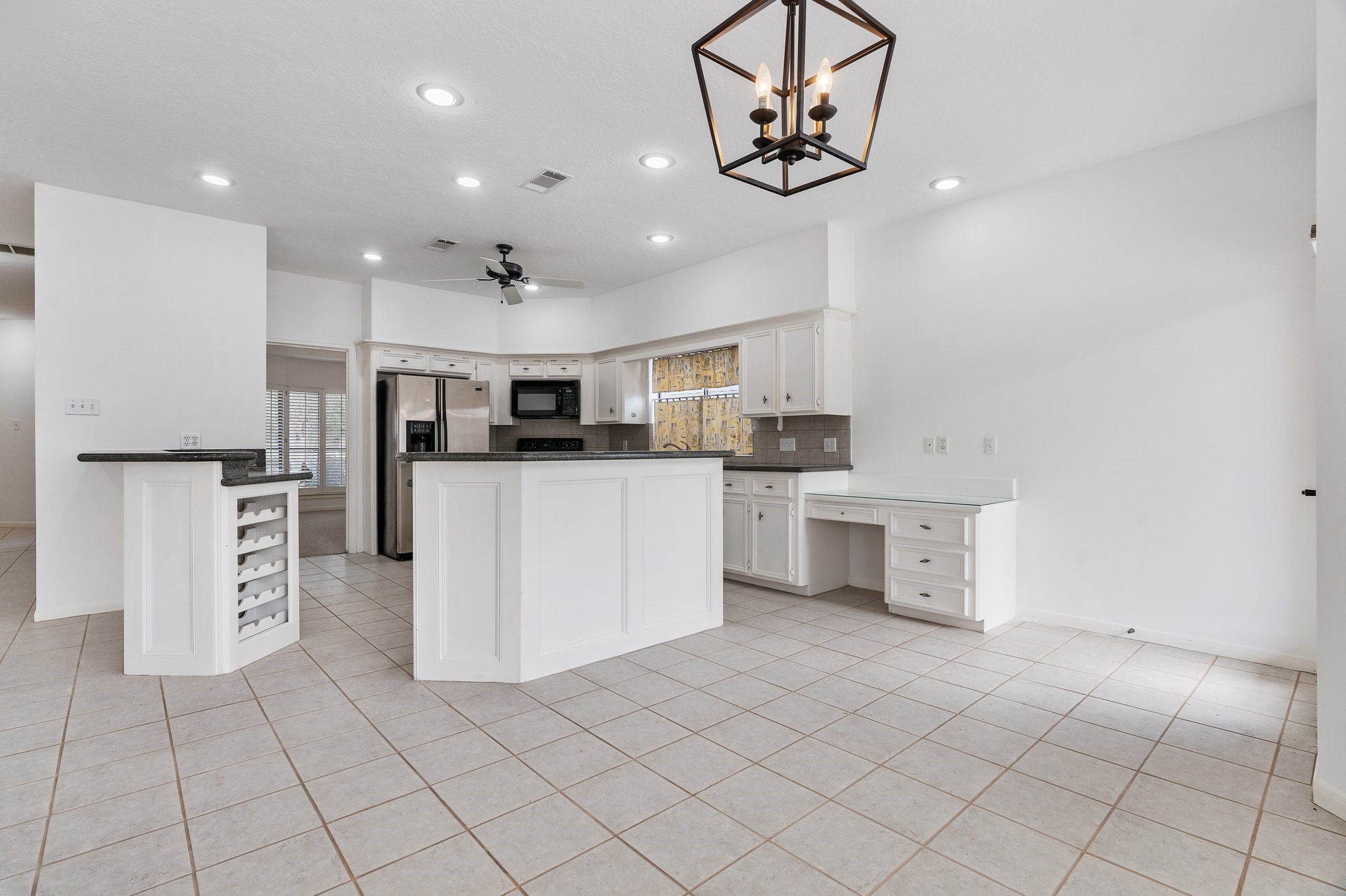 Open floor plan for kitchen, breakfast and family rooms. The kitchen is surrounded by two bar areas, perfect to keep the cook company! There is a convenient desk area also.