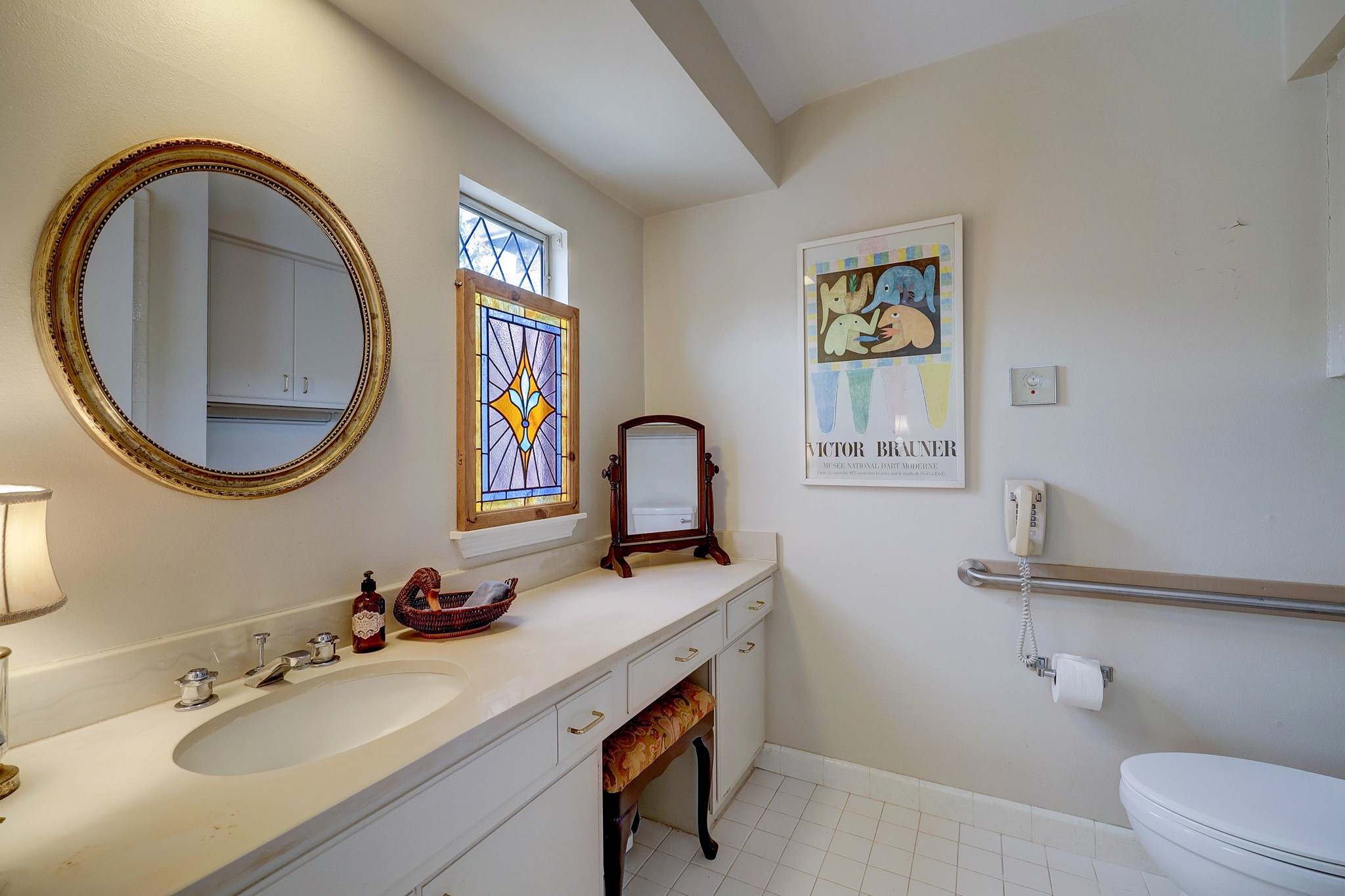 Second of the primary bathrooms. Featuring tile flooring, diamond cut glass window, and a walk-in shower.  The vanity has room to add a second sink if desired.