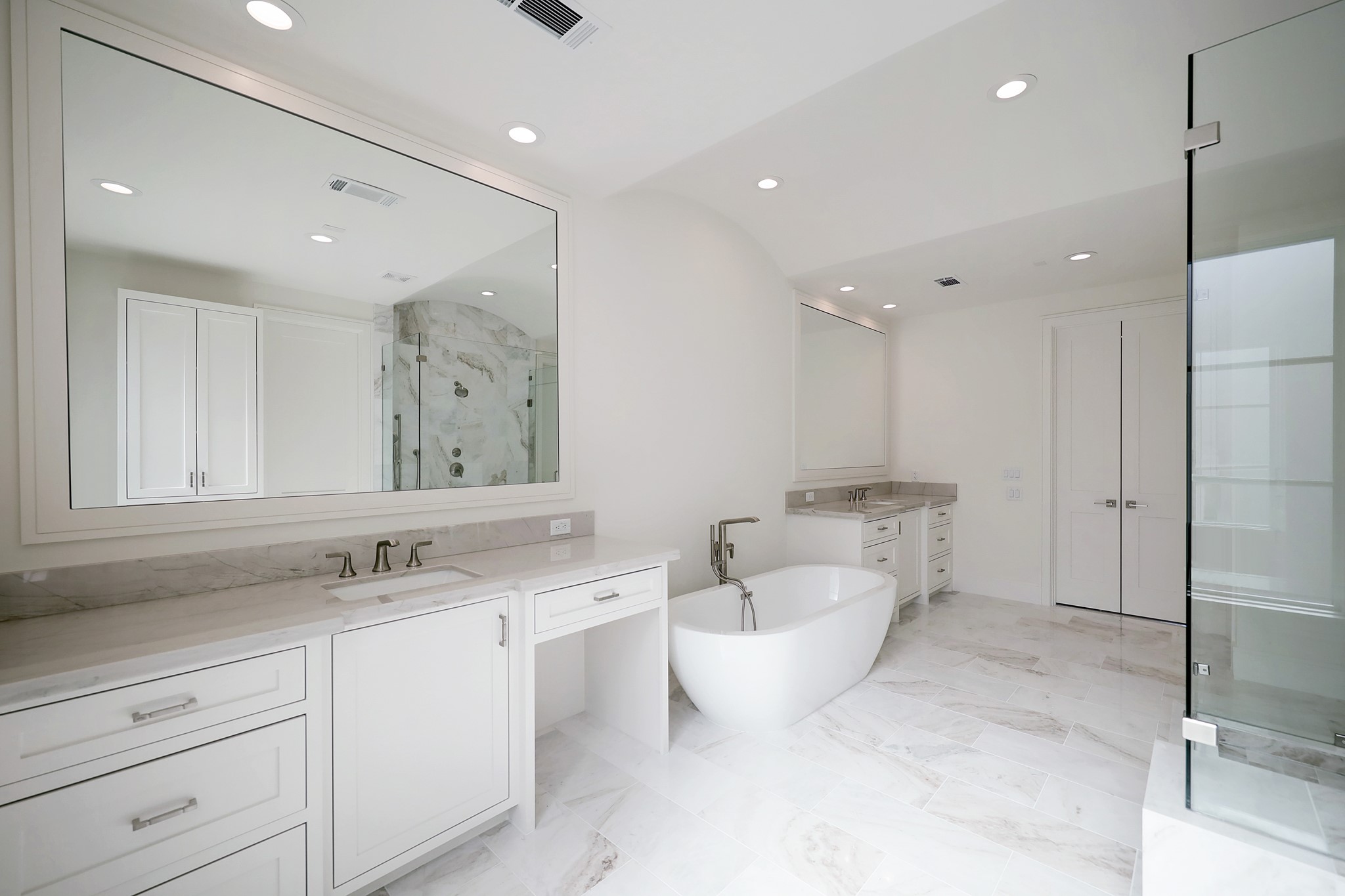 Beautiful primary bathroom with natural marble floors and counter tops