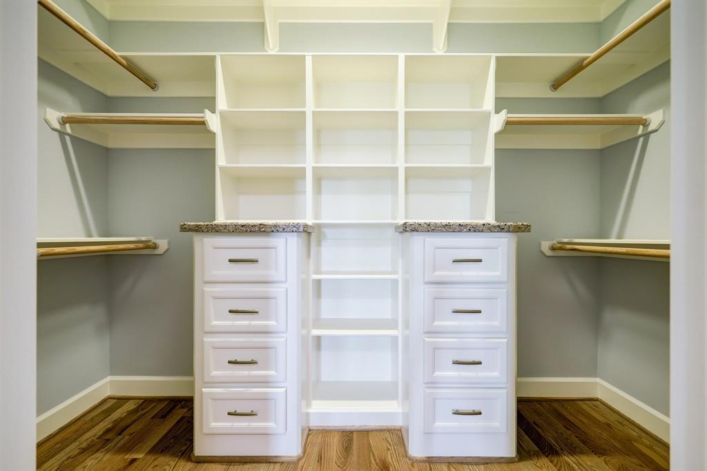 Awesome walk in closet with built in shelves and drawers.
