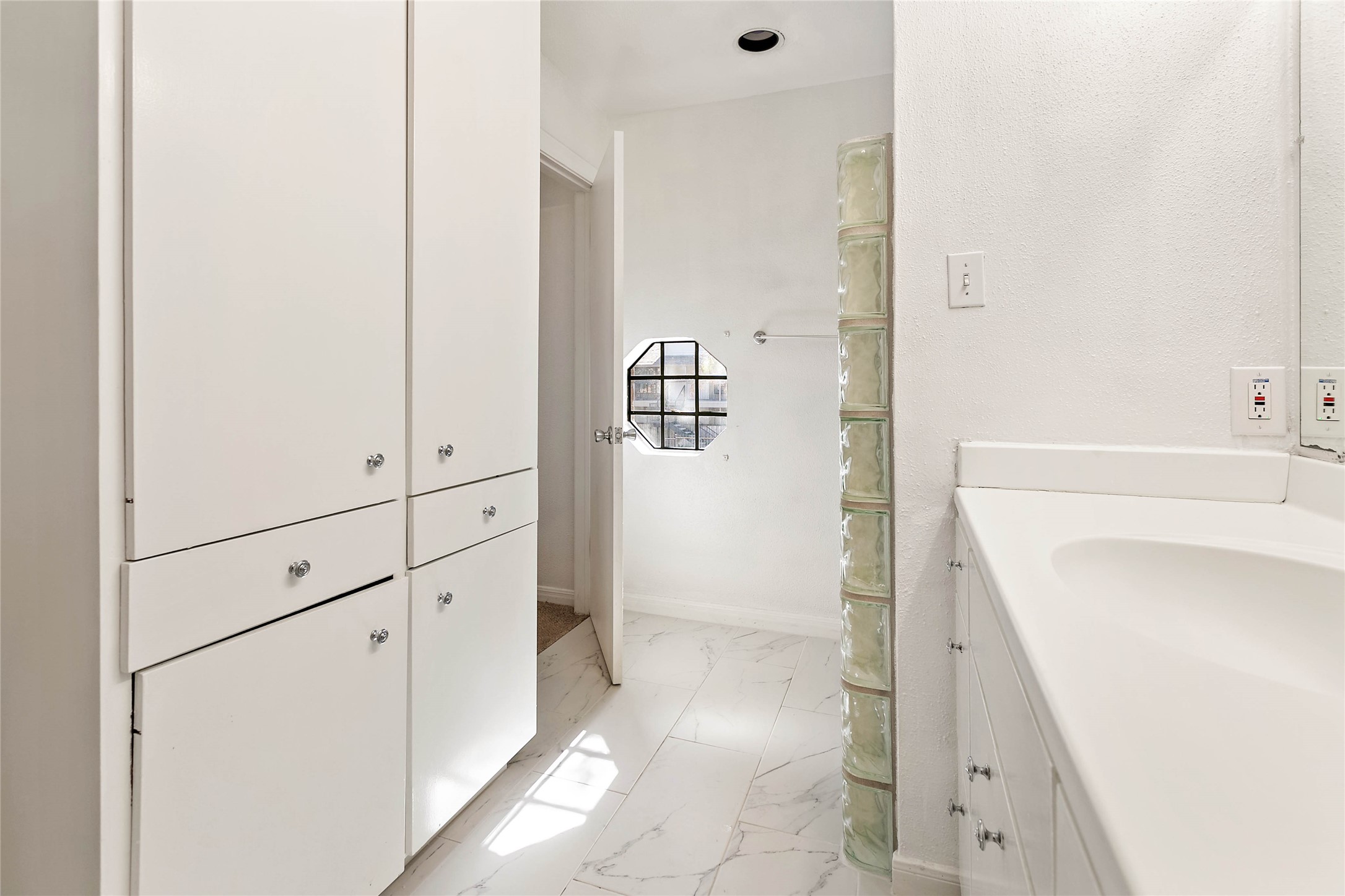 Built-ins offer storage space in the primary bathroom.