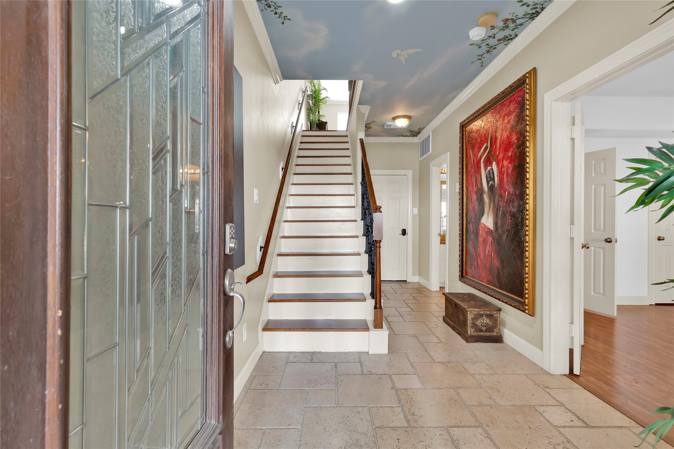 Stepping through the front door, your eyes are drawn upward to the custom hand-painted ceiling in the foyer.