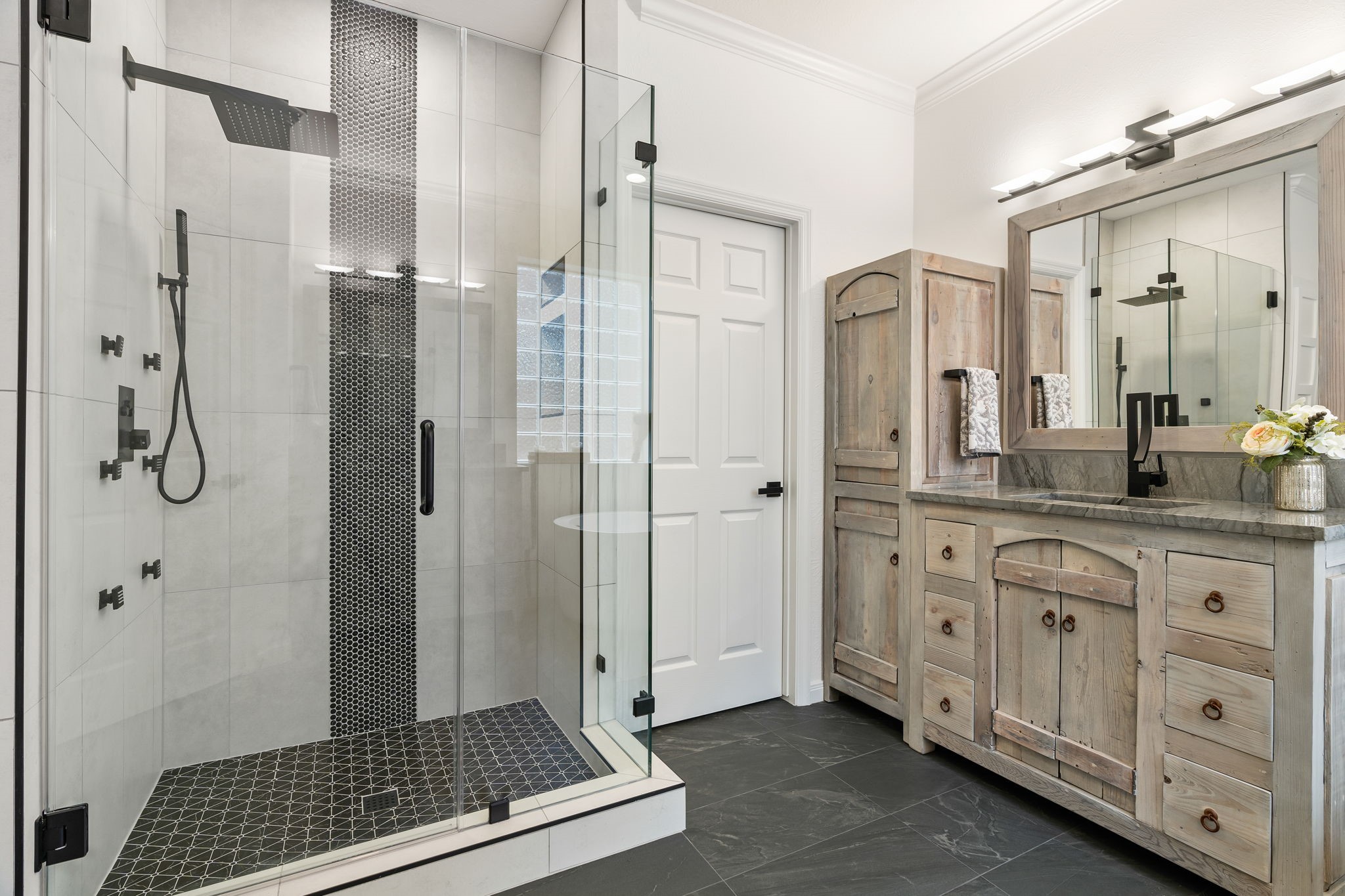 The shower was expanded and look how beautiful it is!  Complete with a rain shower and body jets.  The expansion did not compromise the storage in this bath.