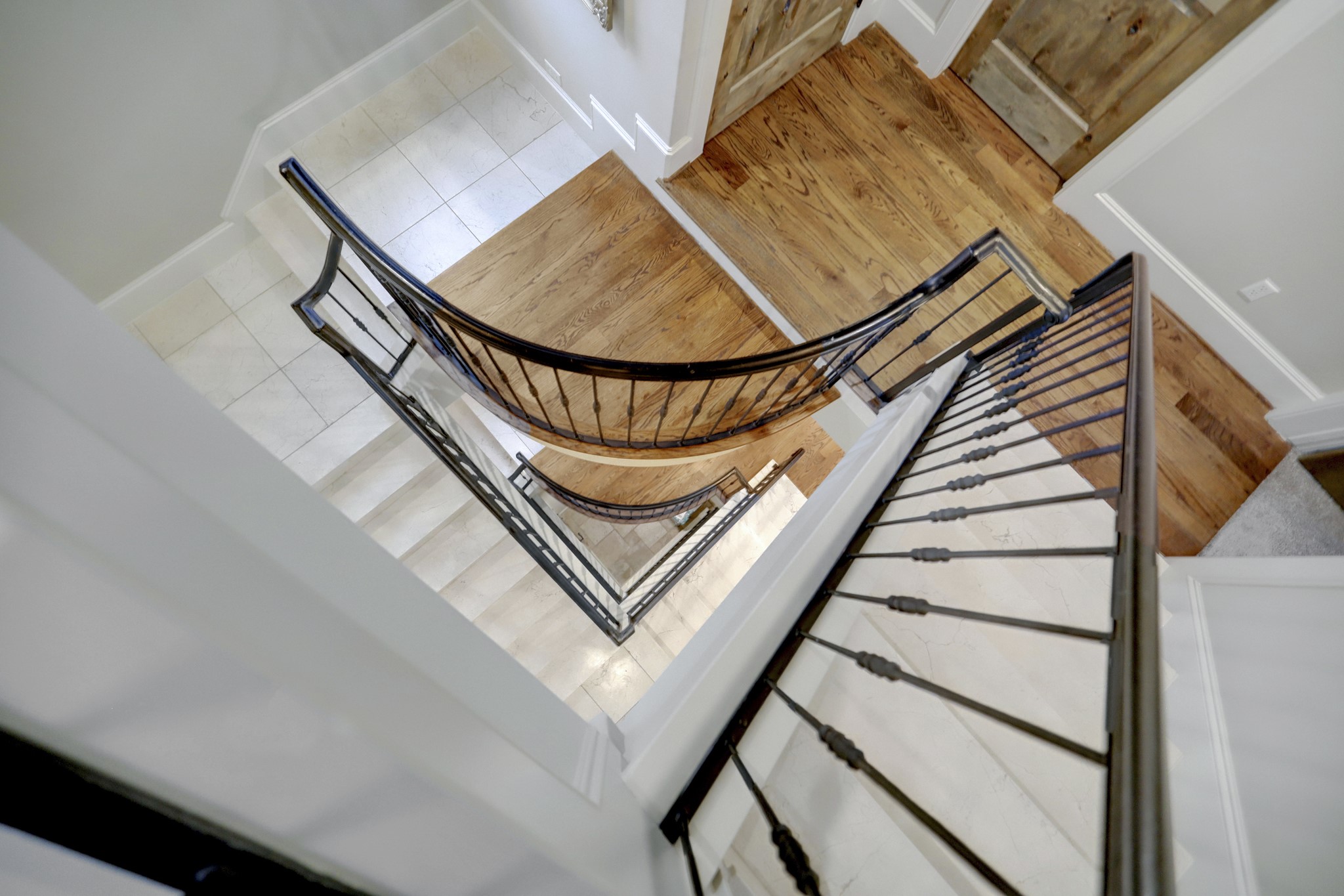 This wow staircase showcases hardwood floors and a rod iron design.